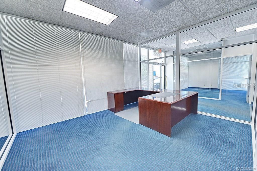 Glass-partitioned office with views across the interior. Glass-partitioned office with views across the interior.