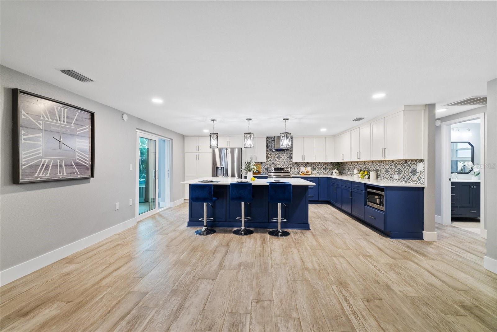 kitchen showing door to guest bedrooms and full bath and sliders to family room