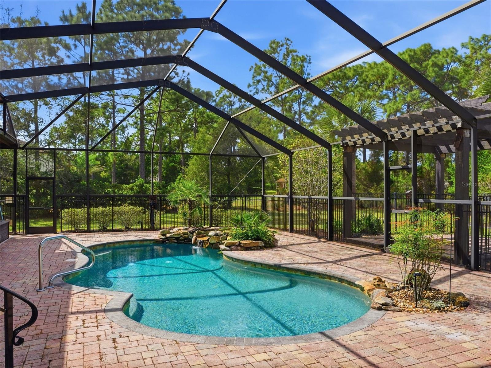 Brick paver pool deck with high screen enclosure!