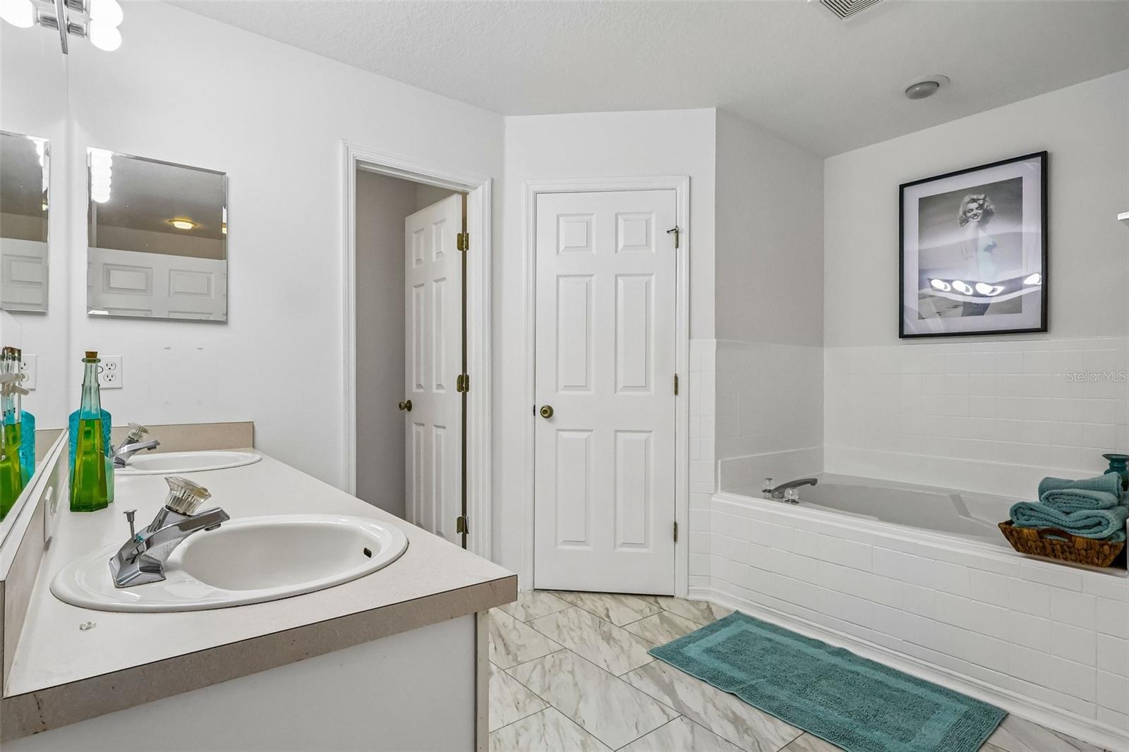 Master bath with water closet, stand up shower, soaking tub, and two walk-in closets.