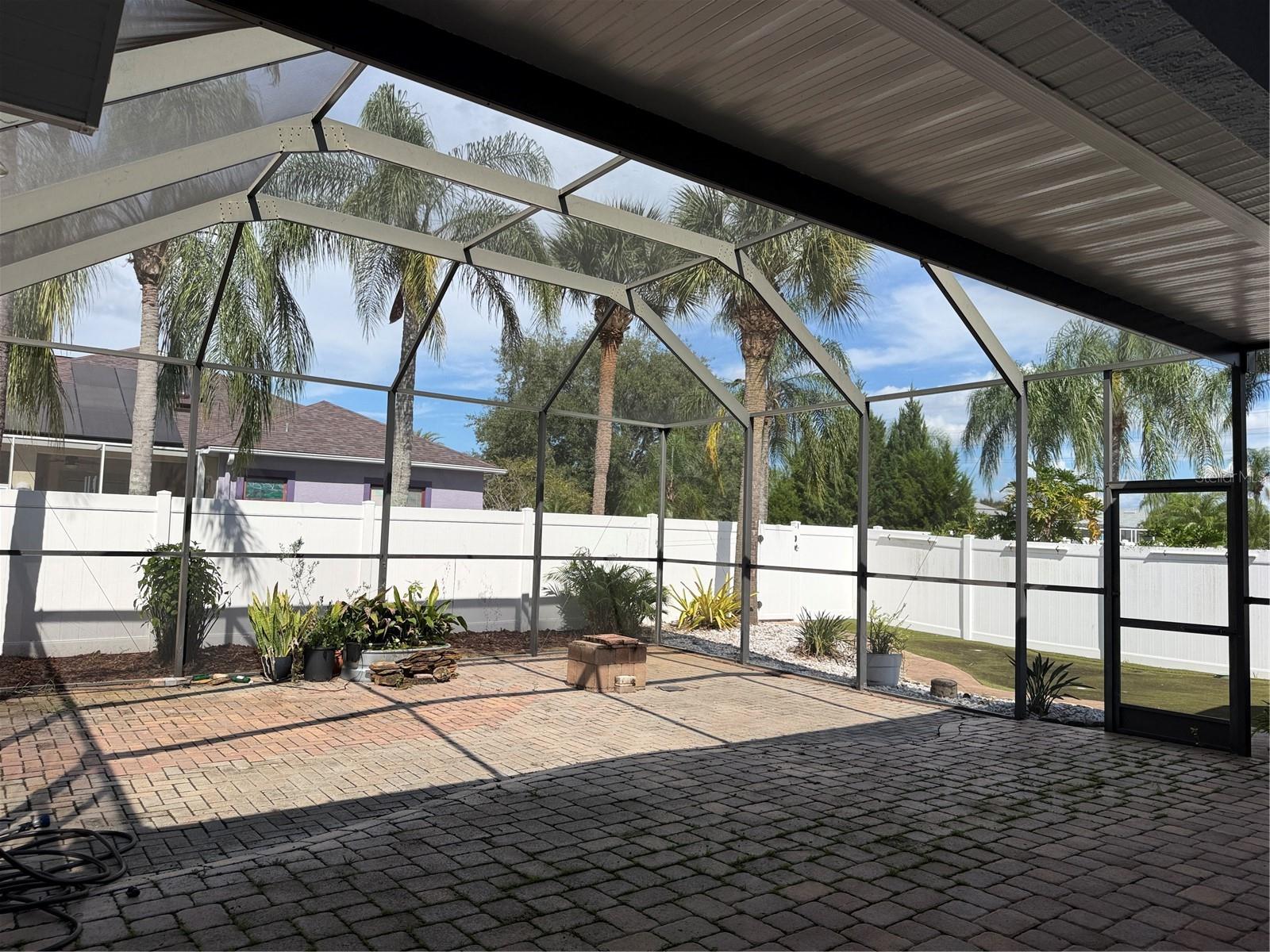 Screened lanai has exits into the backyard from both sides.