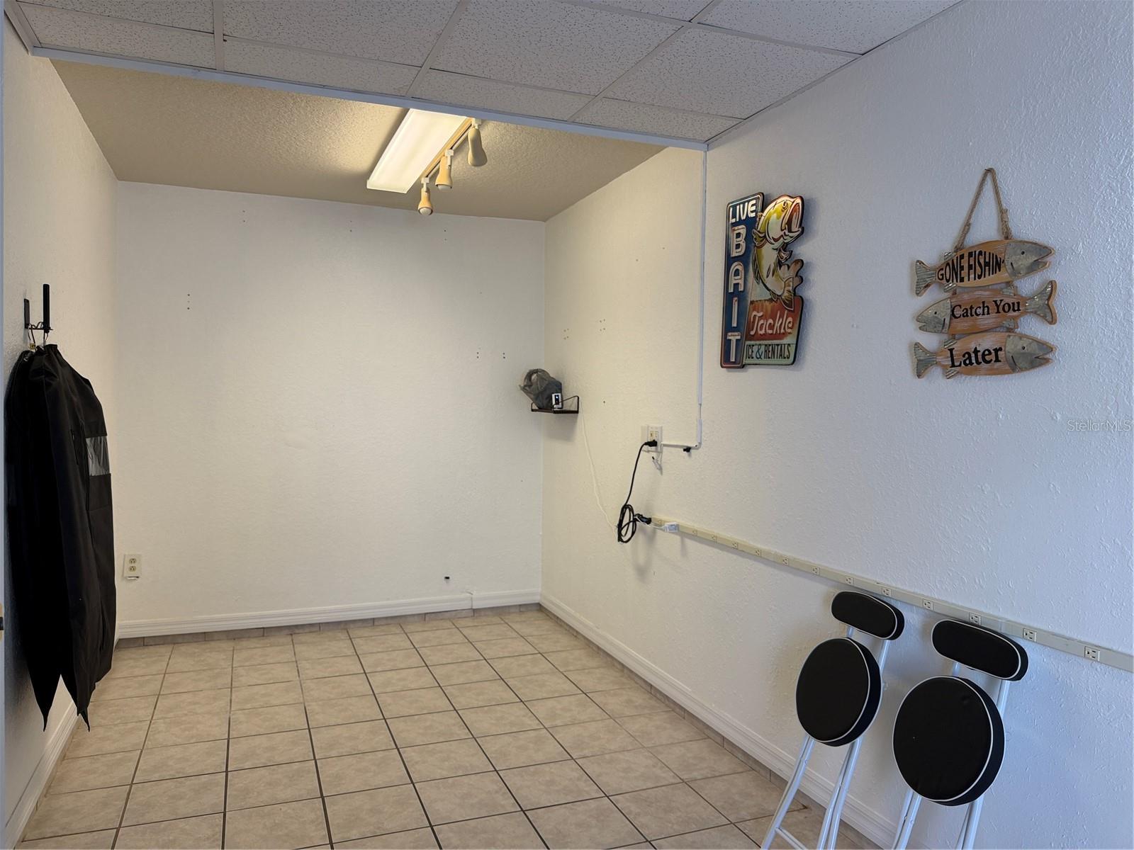 Bonus room in garage has elect plug strip on wall, and tile  flooring