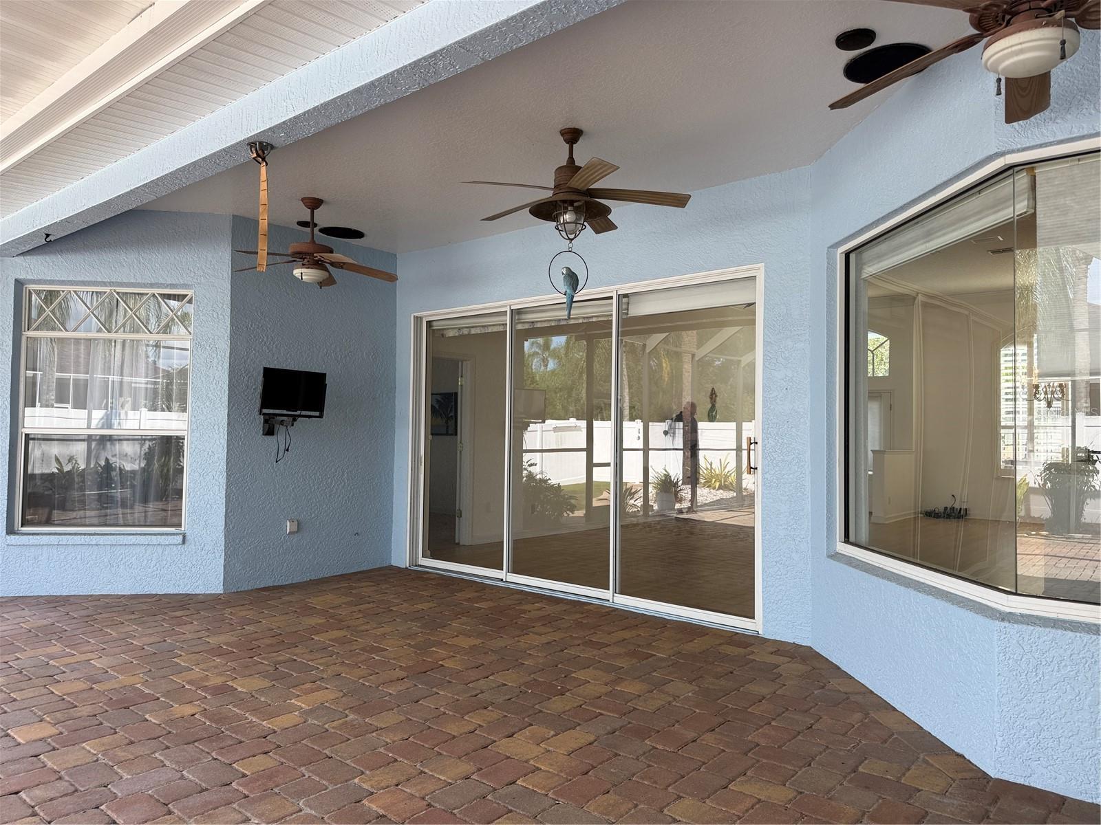 Patio Covered lanai with two ceiling fans and a TV.