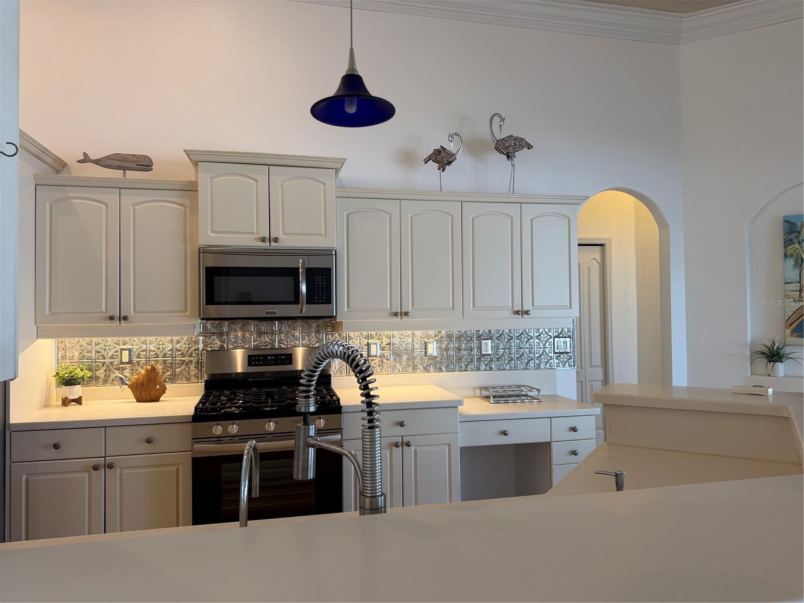 decorative metal tiles adorn the wall under cabinets