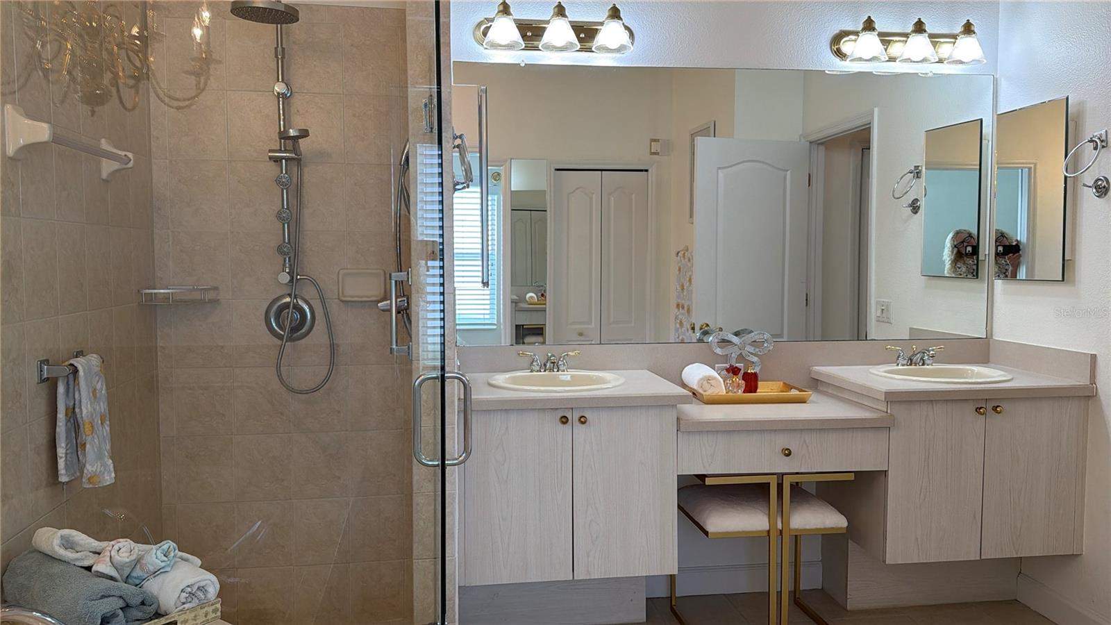 Shower has built in seat, and multiple shower heads and jets