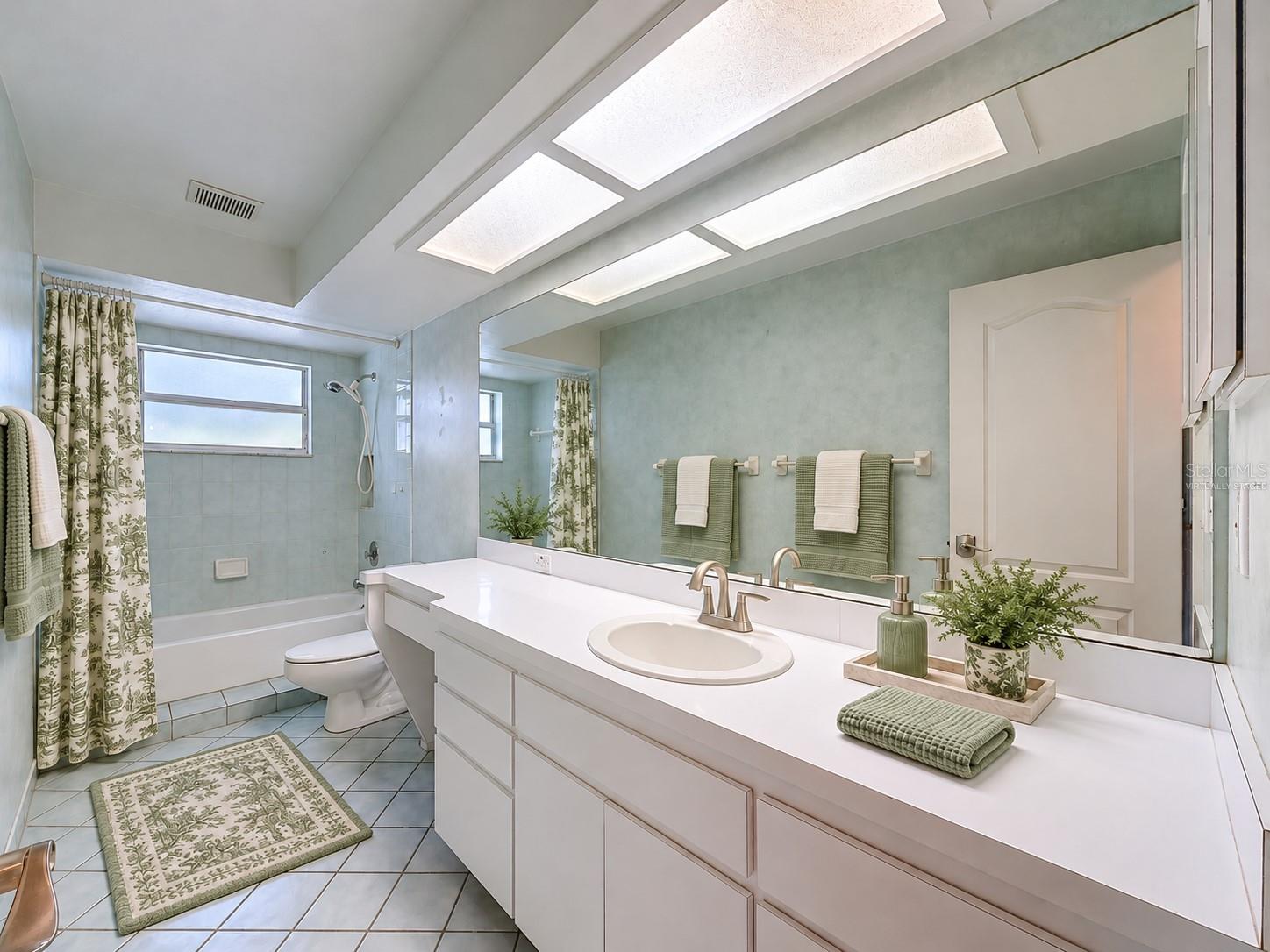 Hall bathroom is large with lots of storage. (virtually staged)