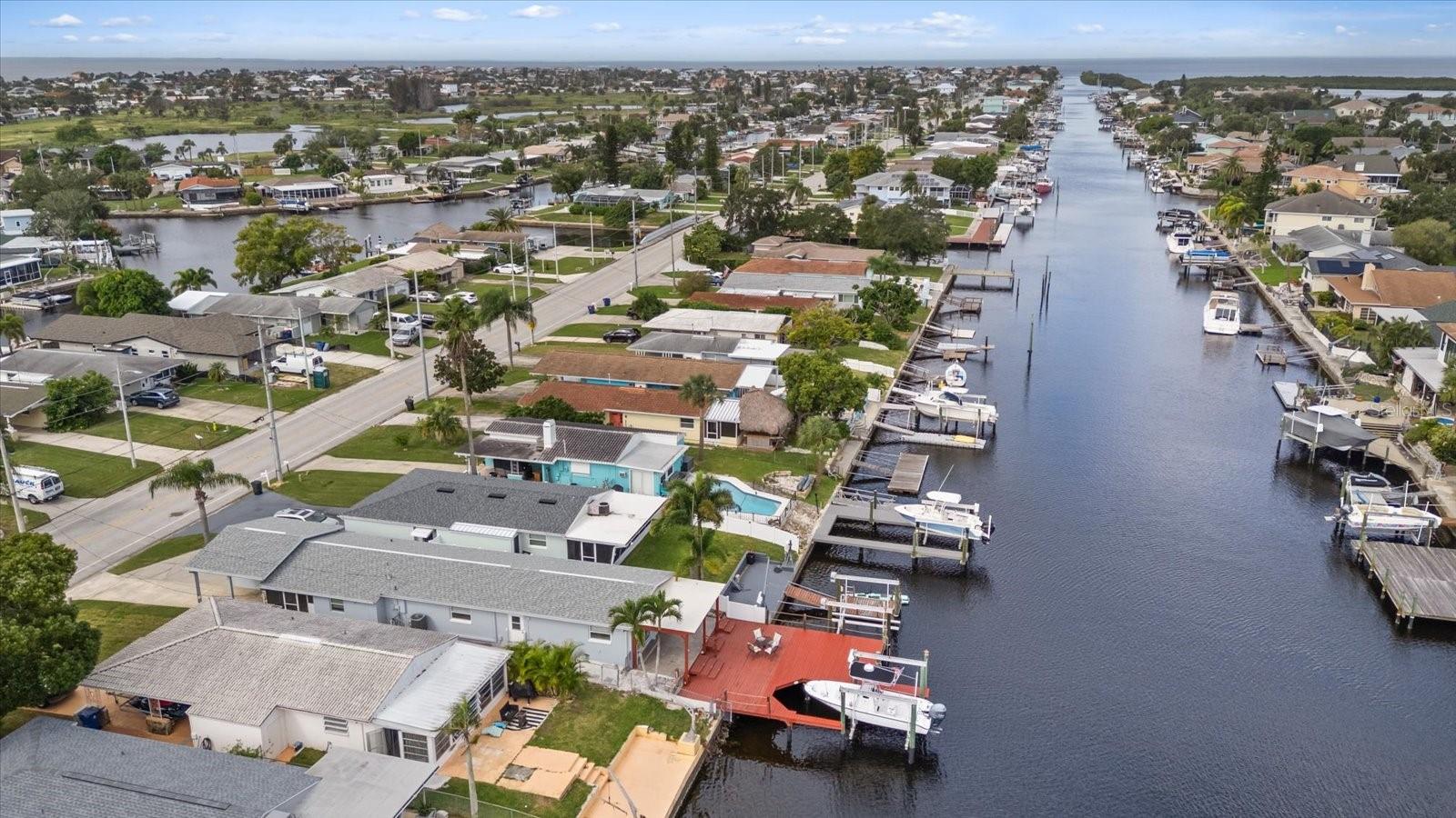 Aerial view of home with red deck and boat lift in North Channel looking west.