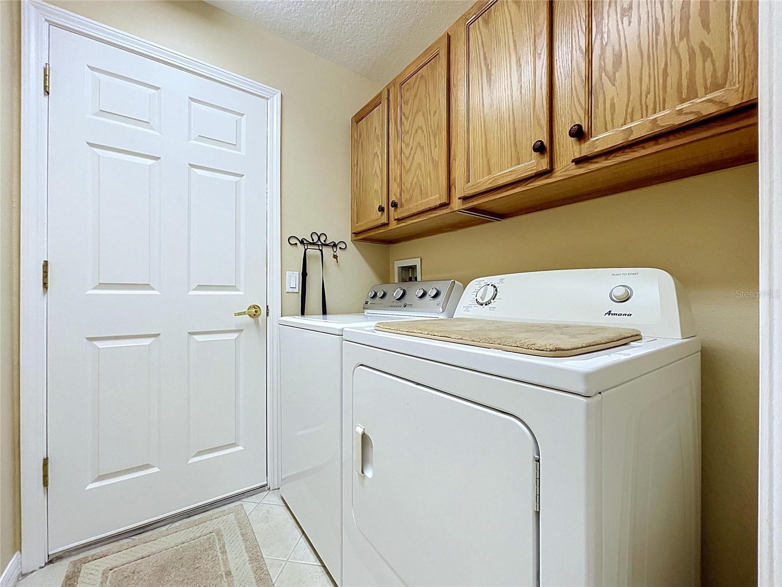 Separate laundry room with cabinets