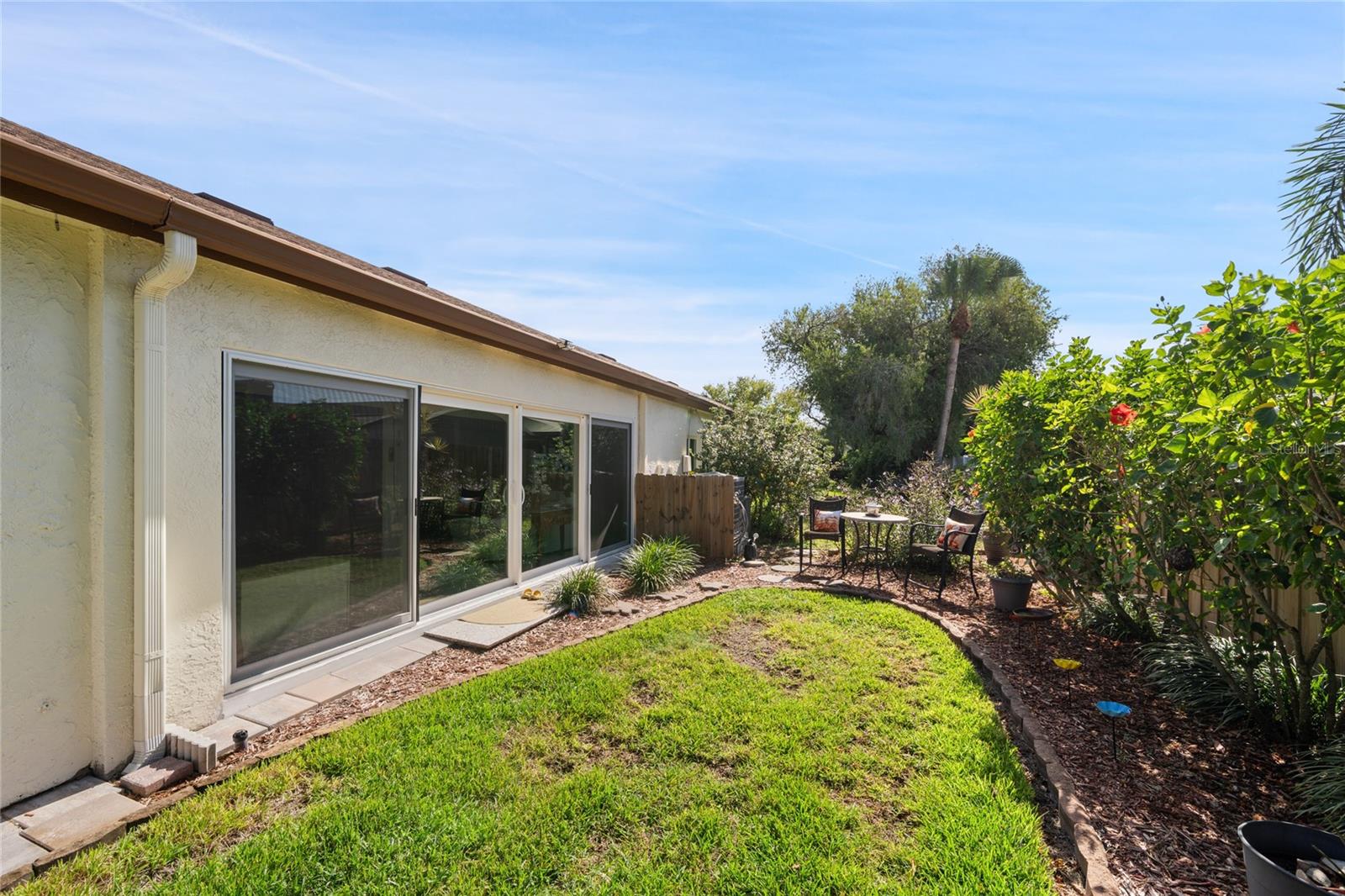 REAR VIEW WITH SEATING AREA.  THERE ARE FRENCH DRAINS FOR STORM DRAINAGE IN BACK YARD.