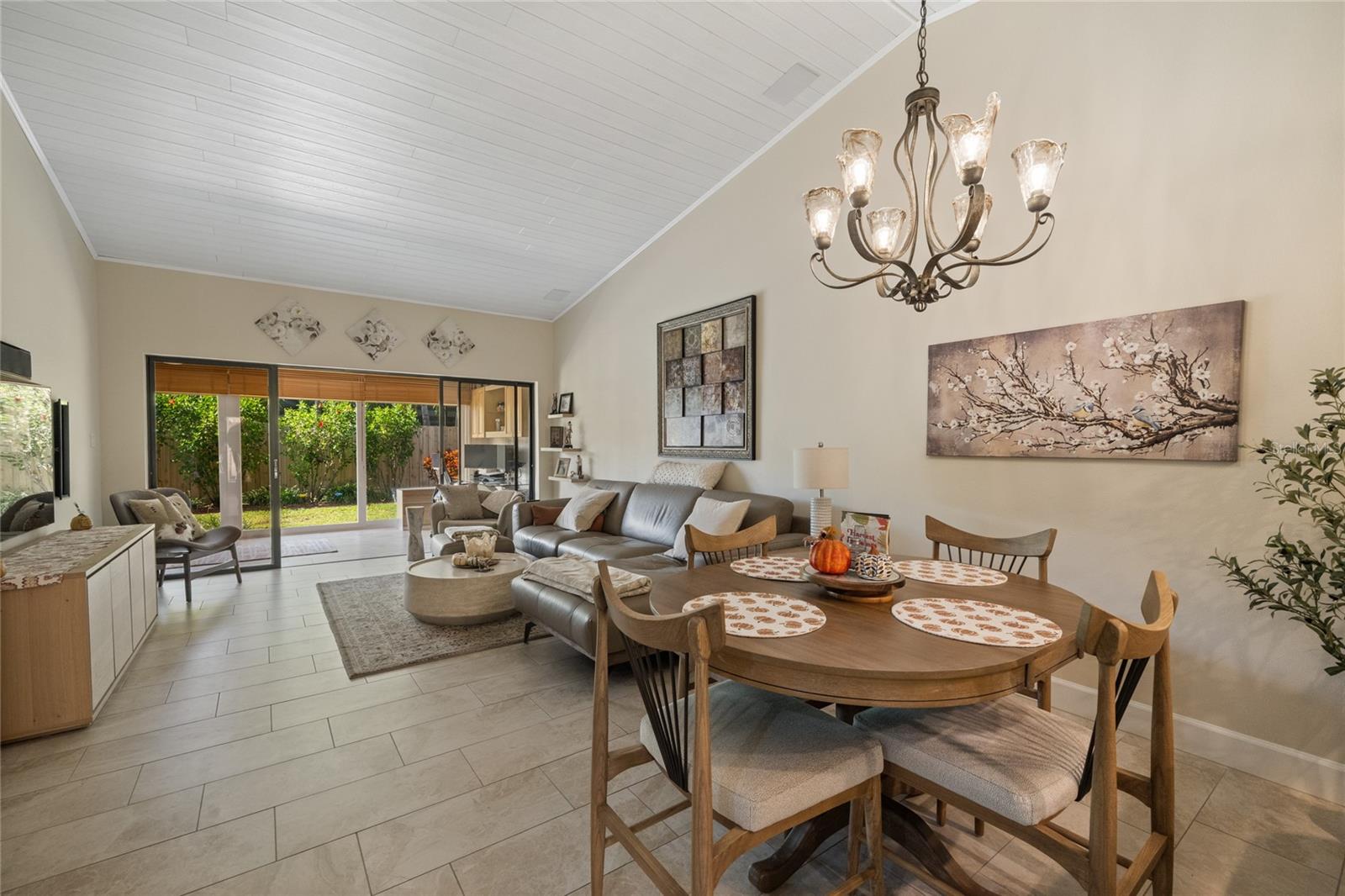 GREAT ROOM/LIVING ROOM AND DINING AREA WITH VIEW OUT TO ENCLOSED LANAI