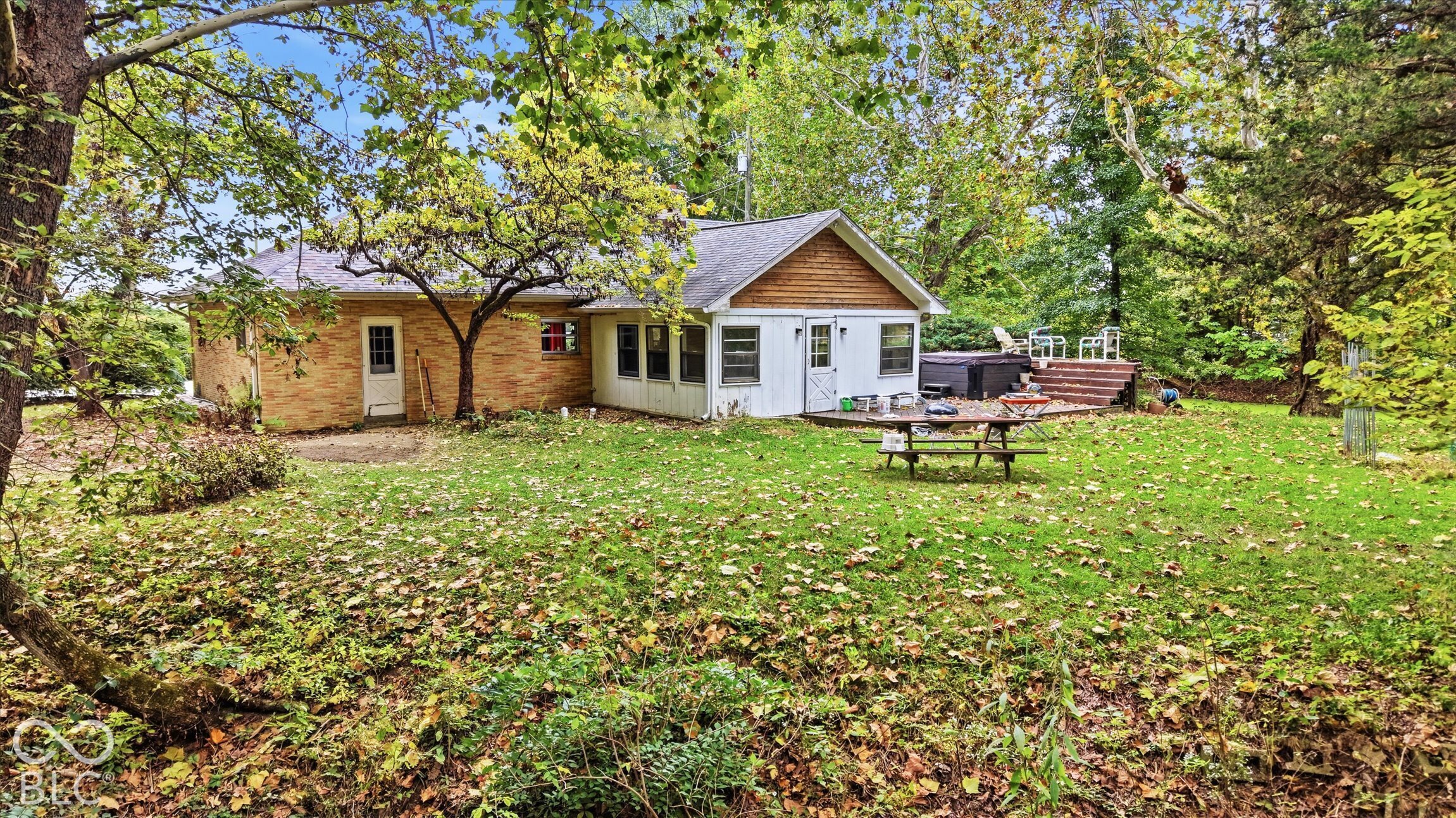 Brick exterior with white trim, sunroom, and wood deck