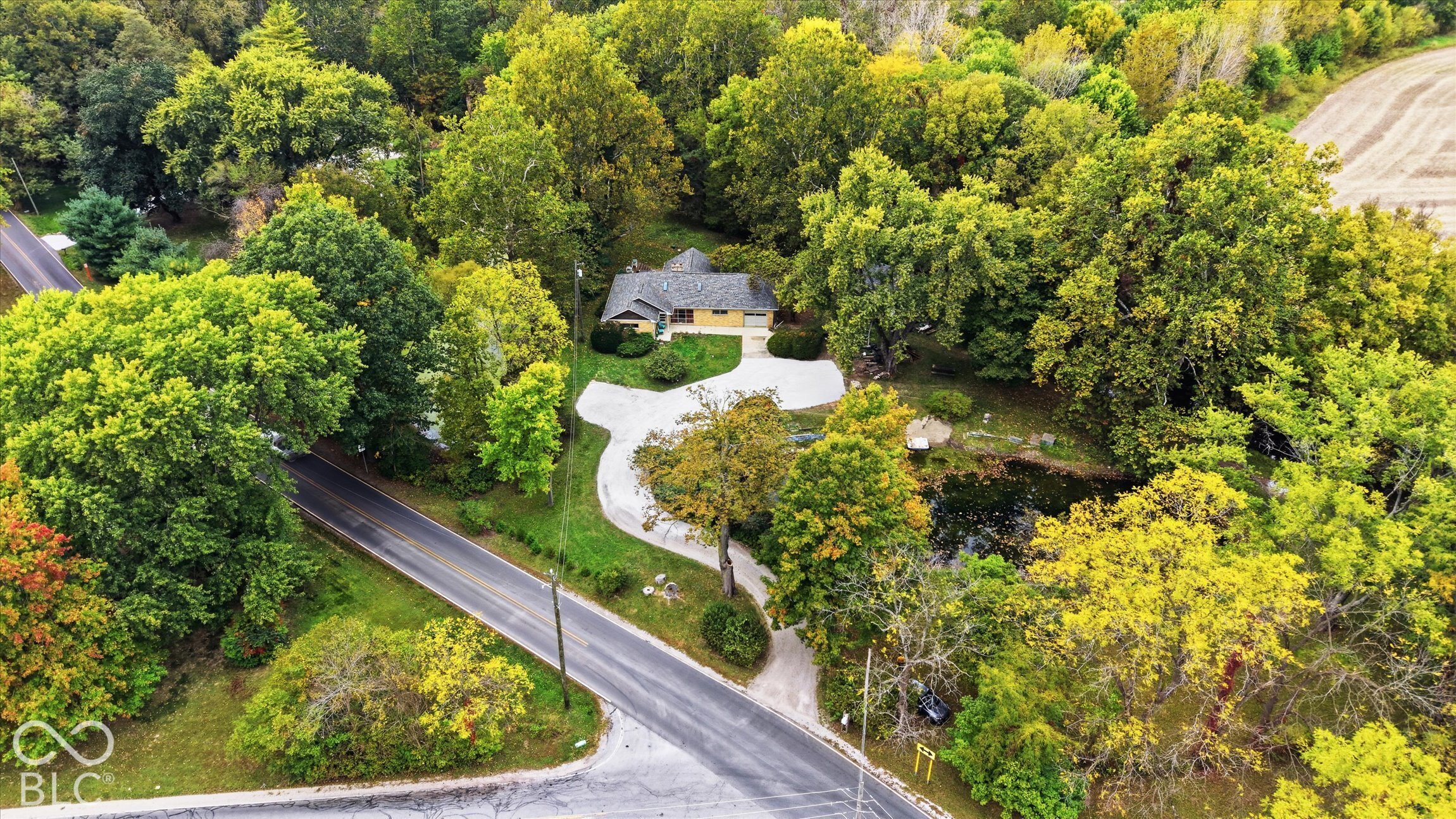 Residential property with a single-story structure, a paved driveway, and mature landscaping