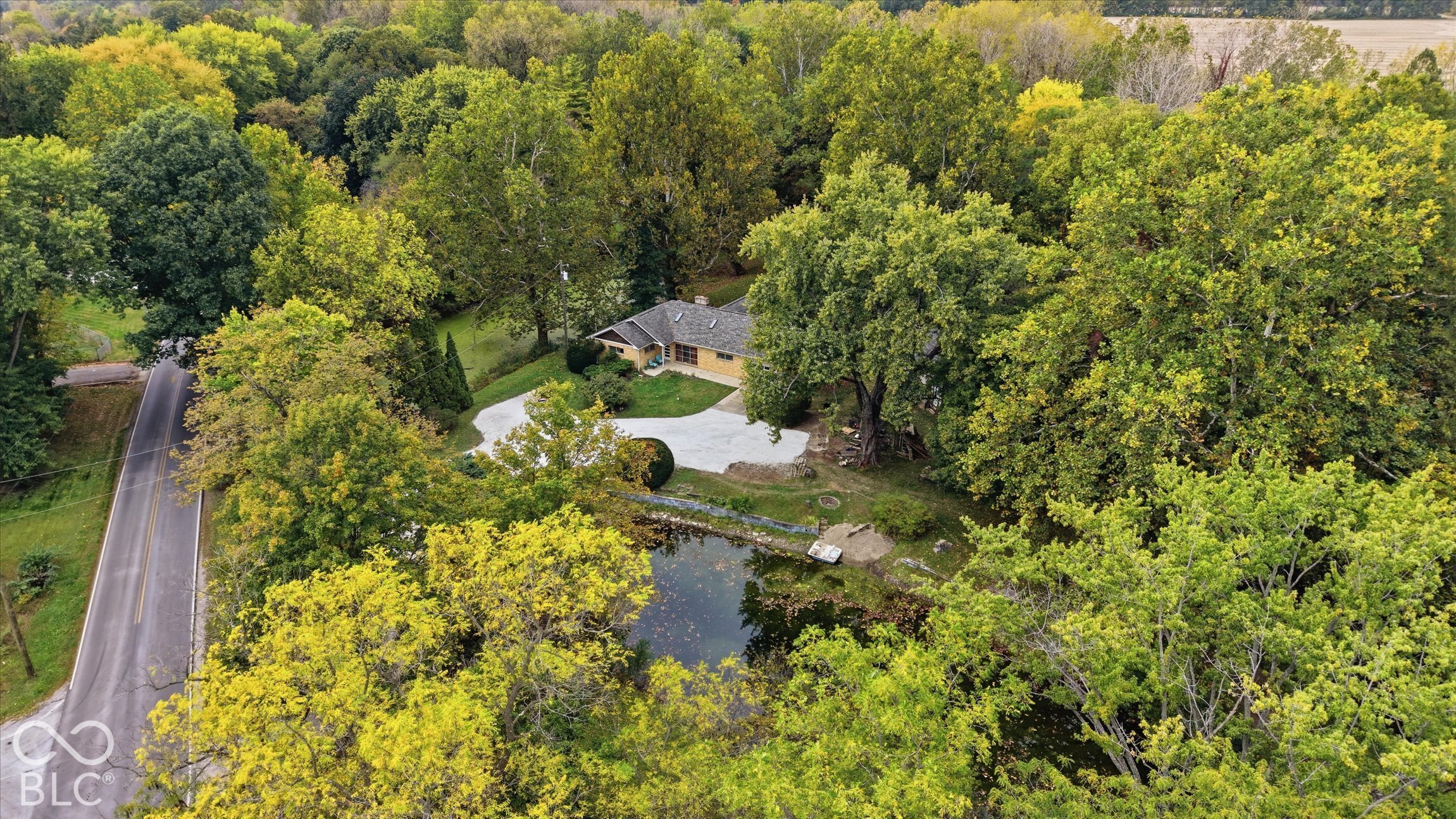 Surrounded by mature trees, this property features a residence  on  Little Eagle Creek, with 2 ponds and a 2 story barn