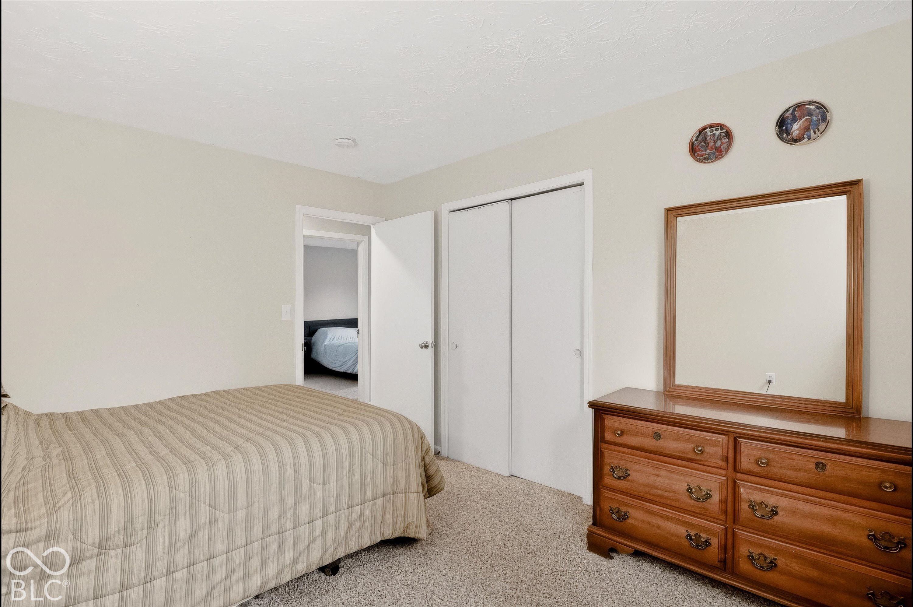 Neutral wall color, wall-to-wall carpeting, and sliding closet doors