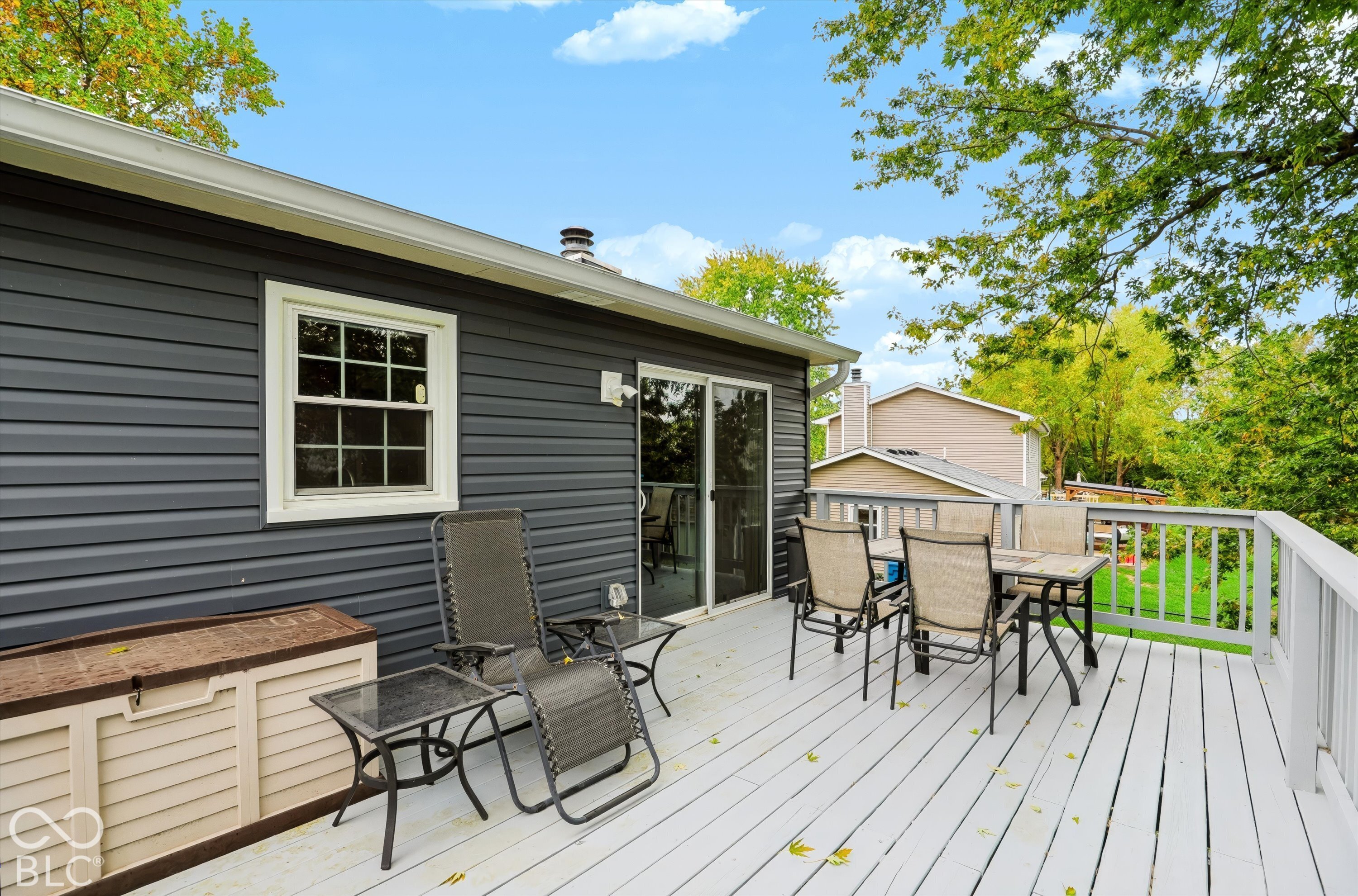 Raised wood deck featuring perimeter railings, horizontal lap siding, and sliding glass door access