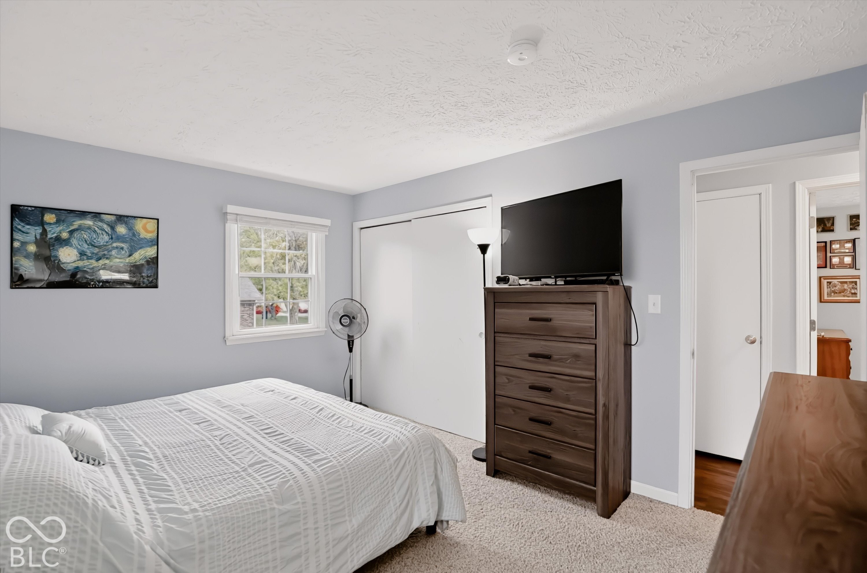 Neutral wall color, dual-panel sliding closet doors, and a single-pane window