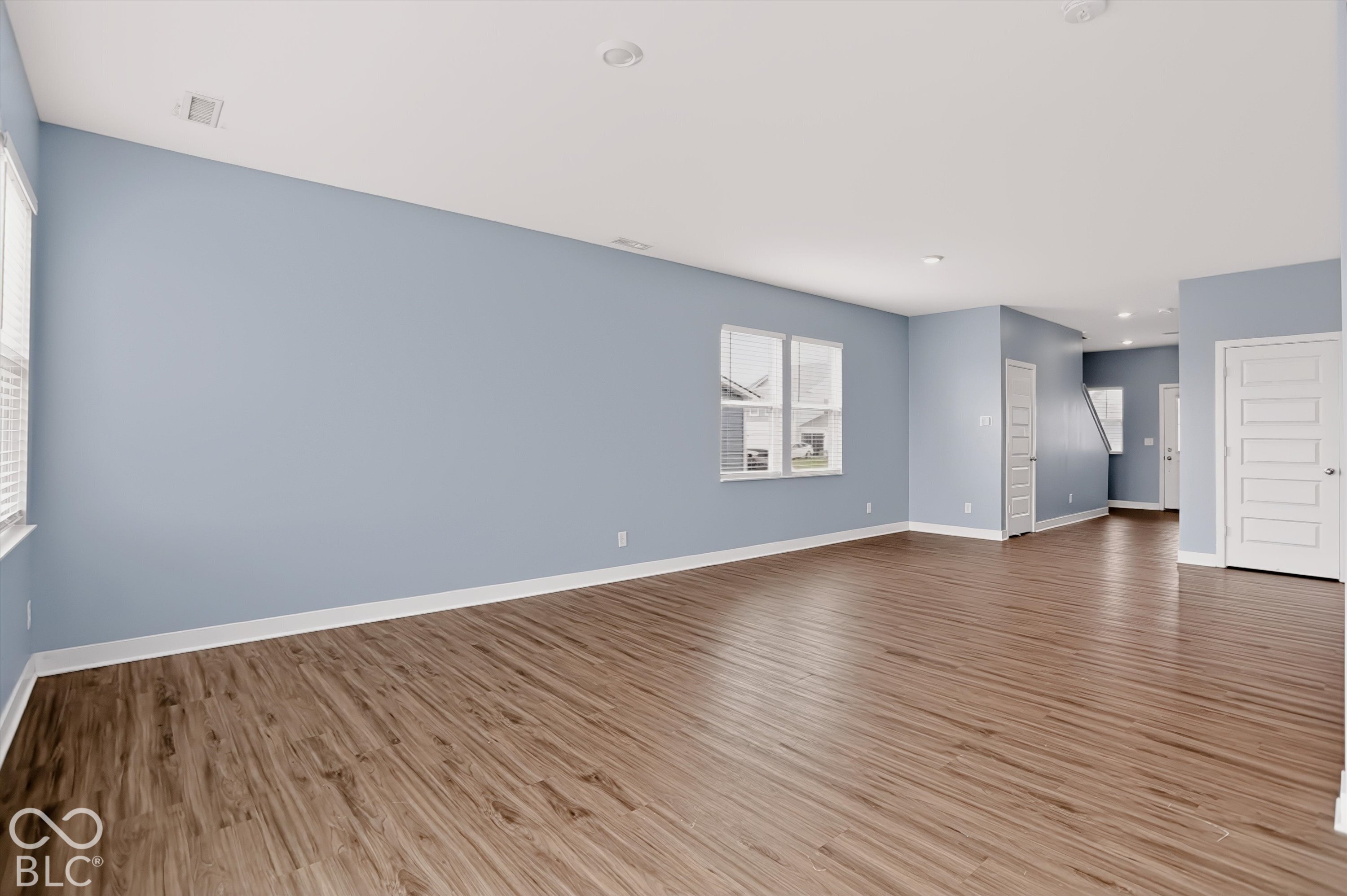 Interior space featuring wood-finish flooring, recessed lighting, multi-panel doors, and double-pane windows