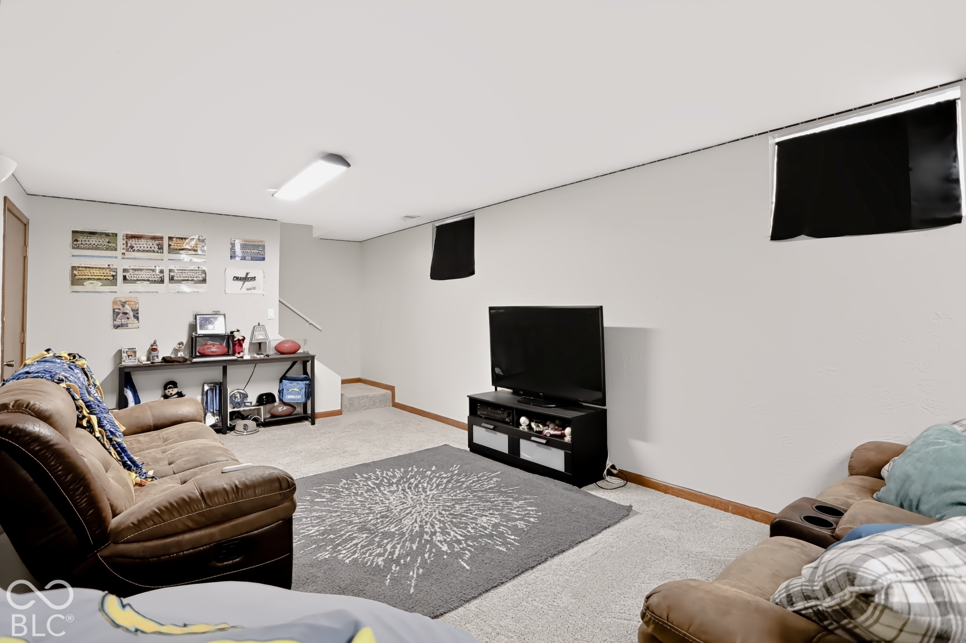 Carpeted flooring, recessed wall cutouts, built-in shelving, and overhead lighting