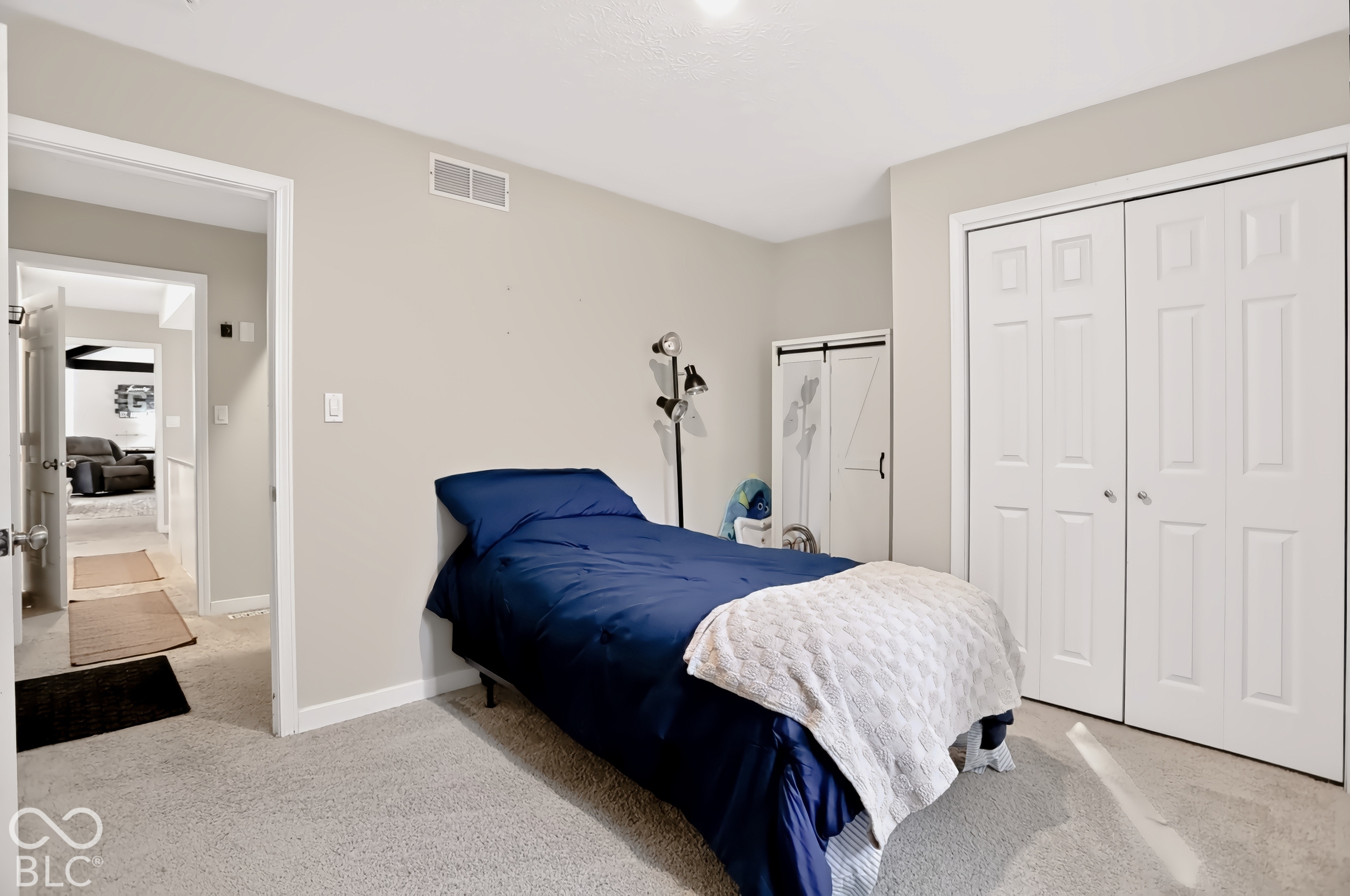 Plush carpeting, neutral wall tones, white trim, and a bi-fold closet