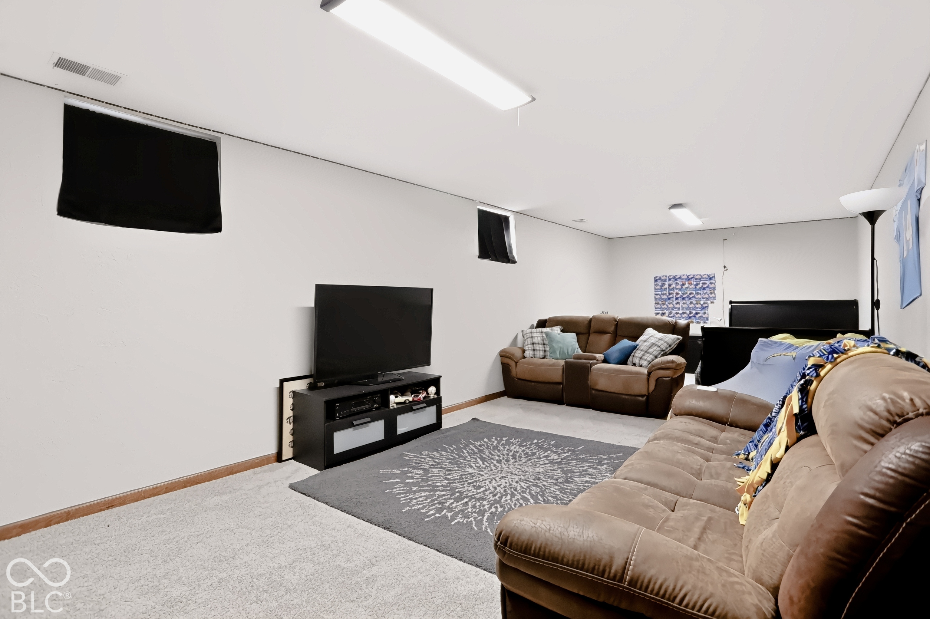 Recessed windows, neutral wall tones, carpeted flooring, and overhead lighting