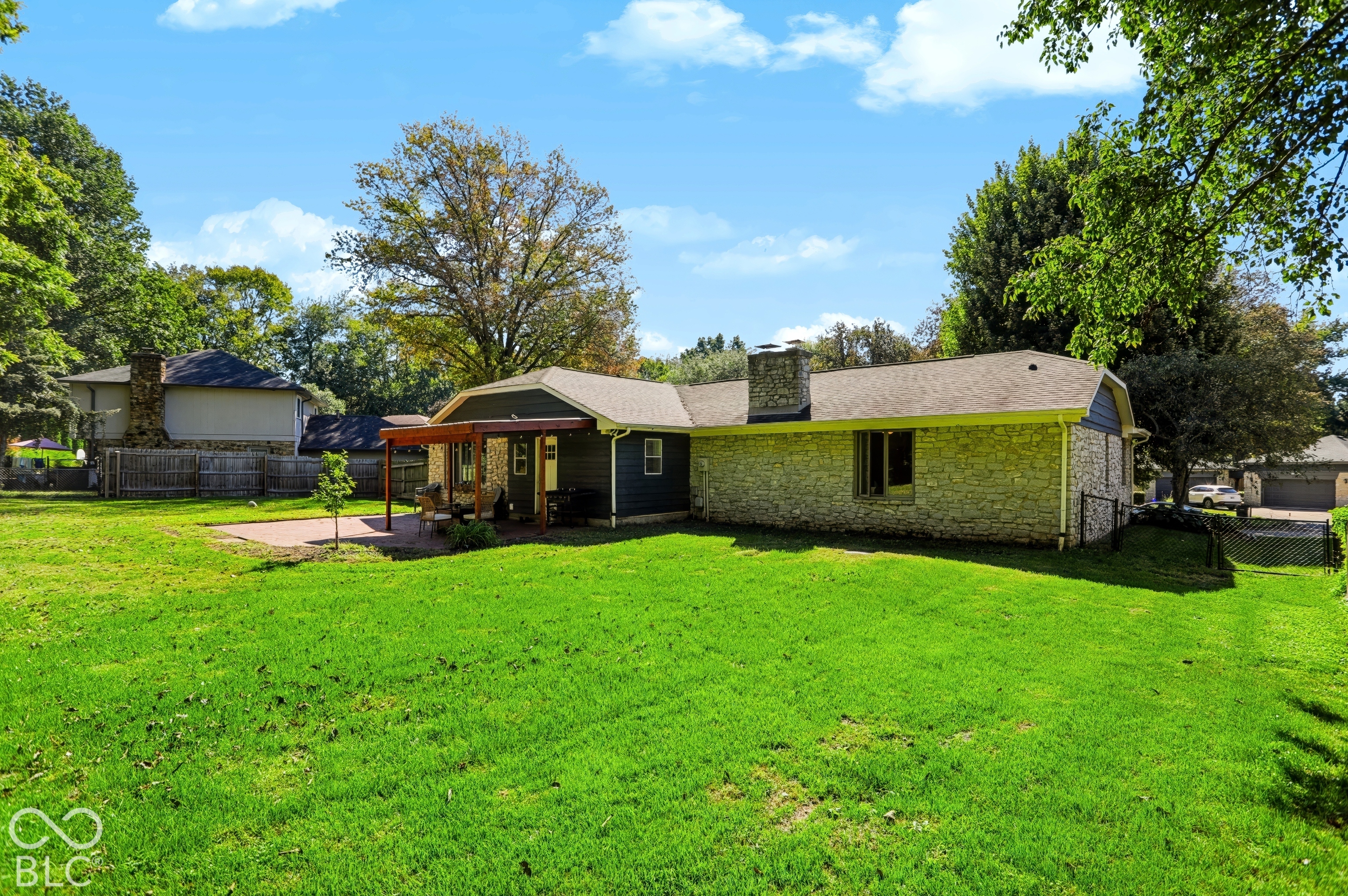 Expansive green lawn with a paver patio and covered outdoor living area