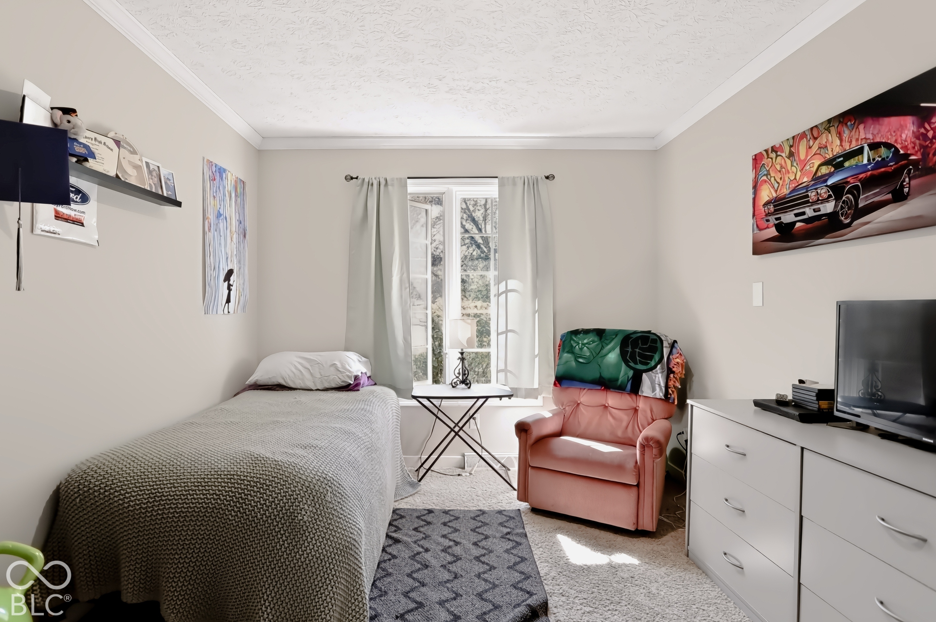 Wall-to-wall carpeting, crown molding, and a built-in wall shelf
