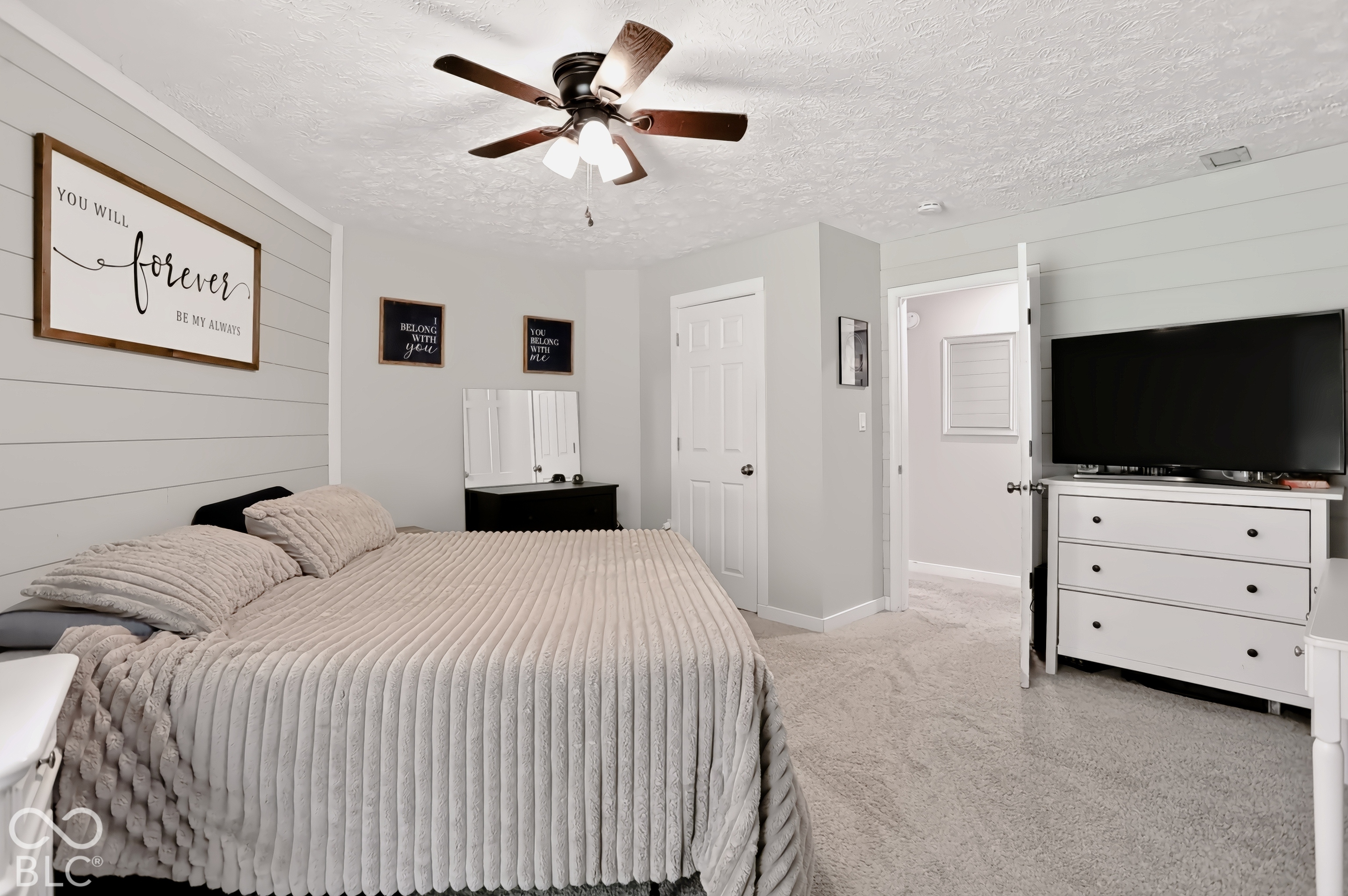 Carpeted flooring, ceiling fan with integrated lighting, flat-panel doors, and a shiplap accent wall
