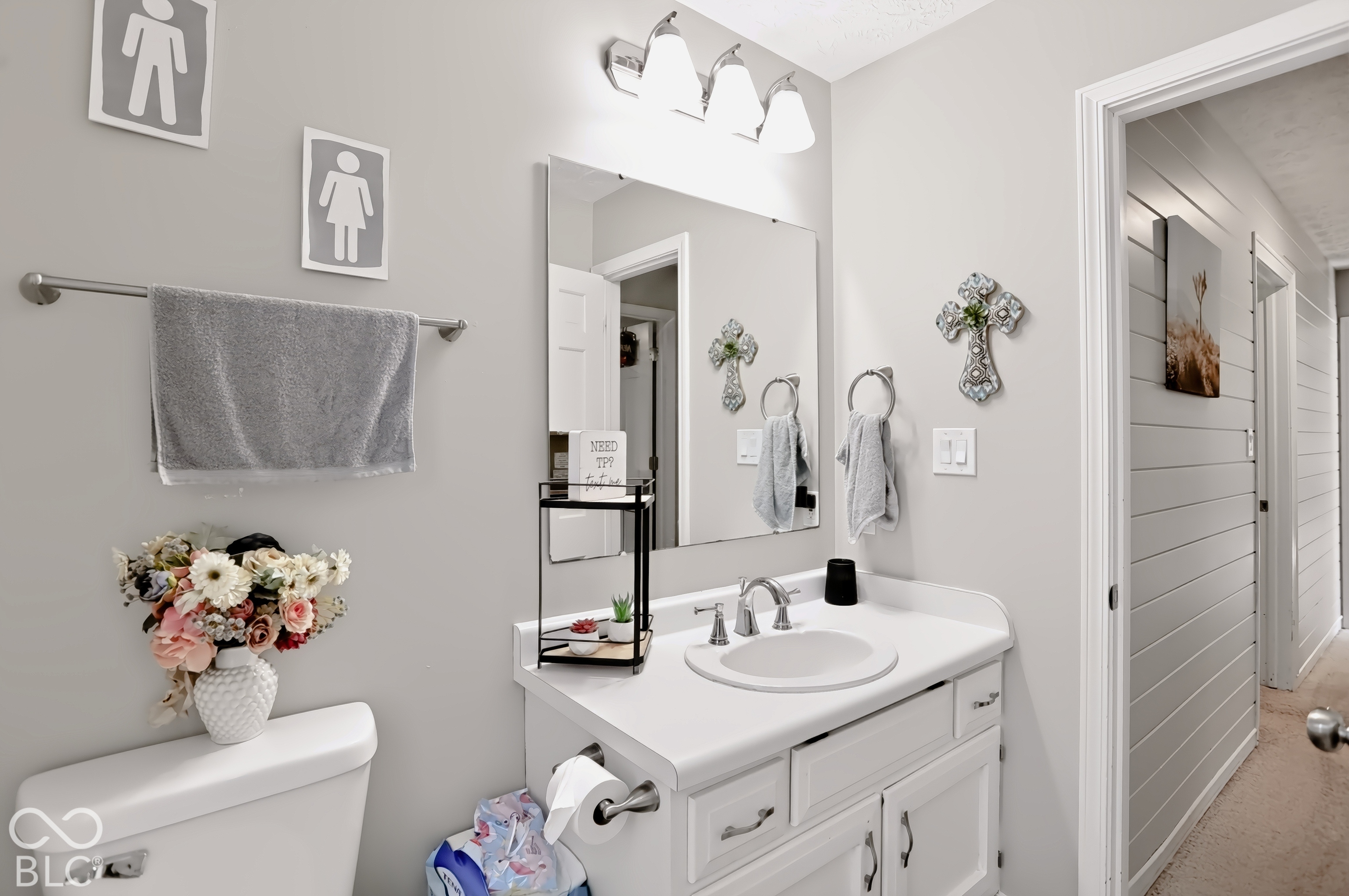 White vanity with integrated sink, chrome-finish faucet, and coordinating light fixture