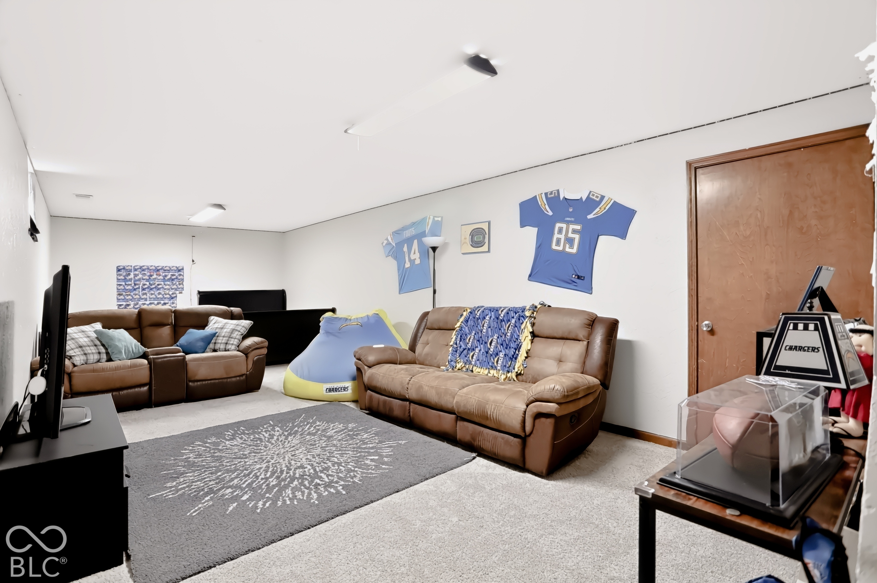 Carpeted flooring, white painted walls, wood-finish interior door, recessed lighting, and a ceiling-mounted light fixture