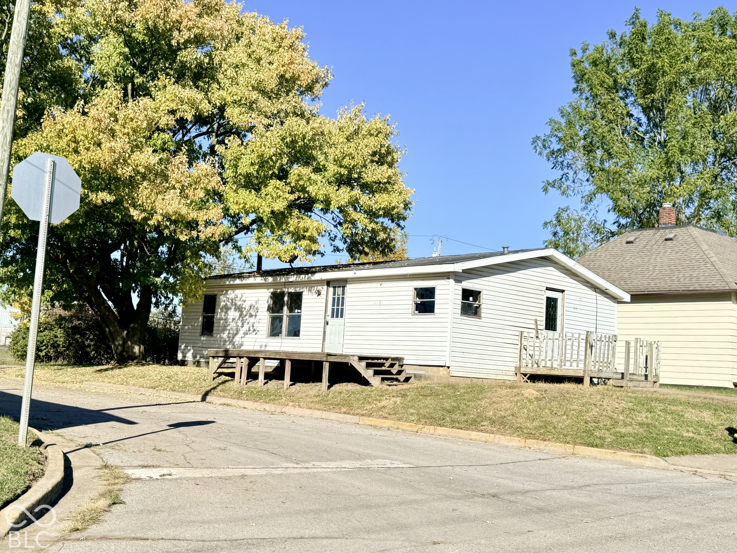 White siding exterior with multiple windows and a front entry door
