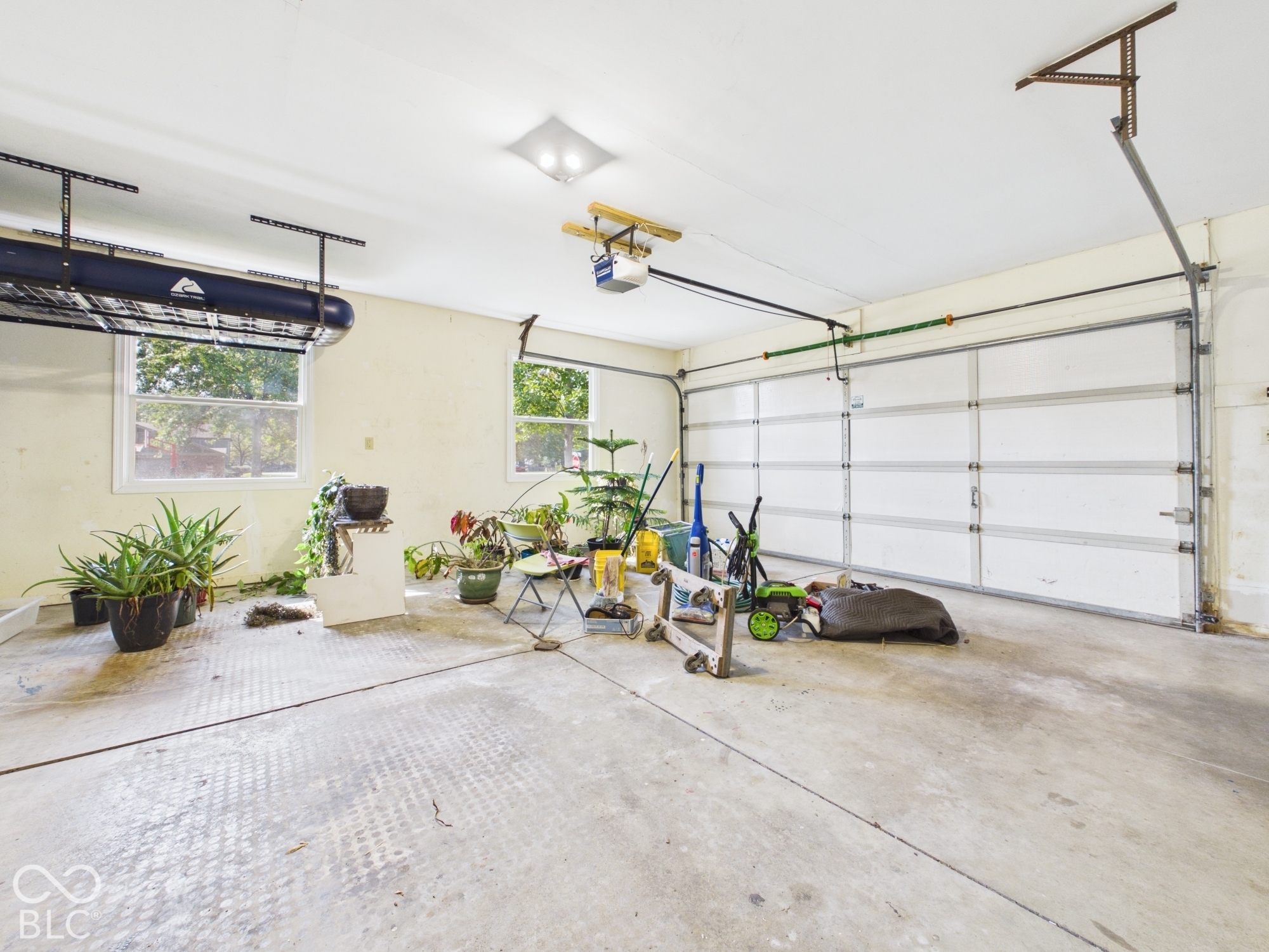 Two-car garage with multiple windows and overhead lighting