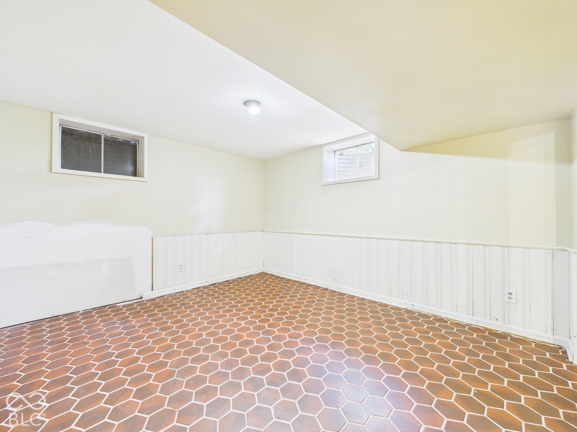 Recessed lighting, two windows, wainscoting, and hexagonal floor tile