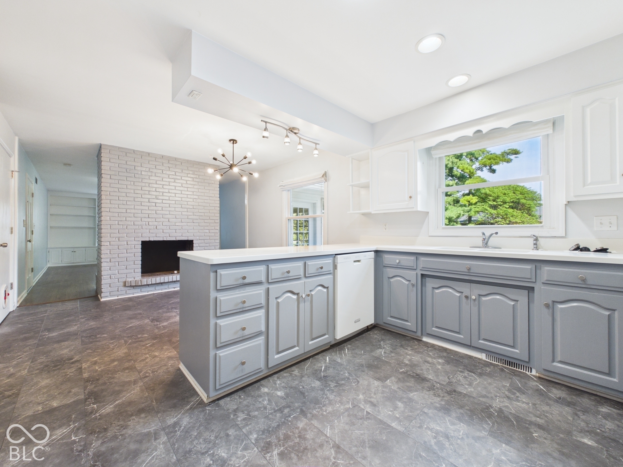 Kitchen featuring gray lower cabinetry, white upper cabinetry, and a white countertop
