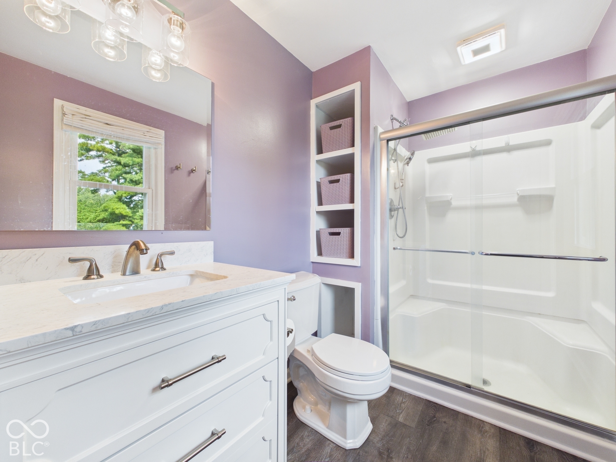 White vanity with brushed nickel hardware, integrated sink, and a white countertop