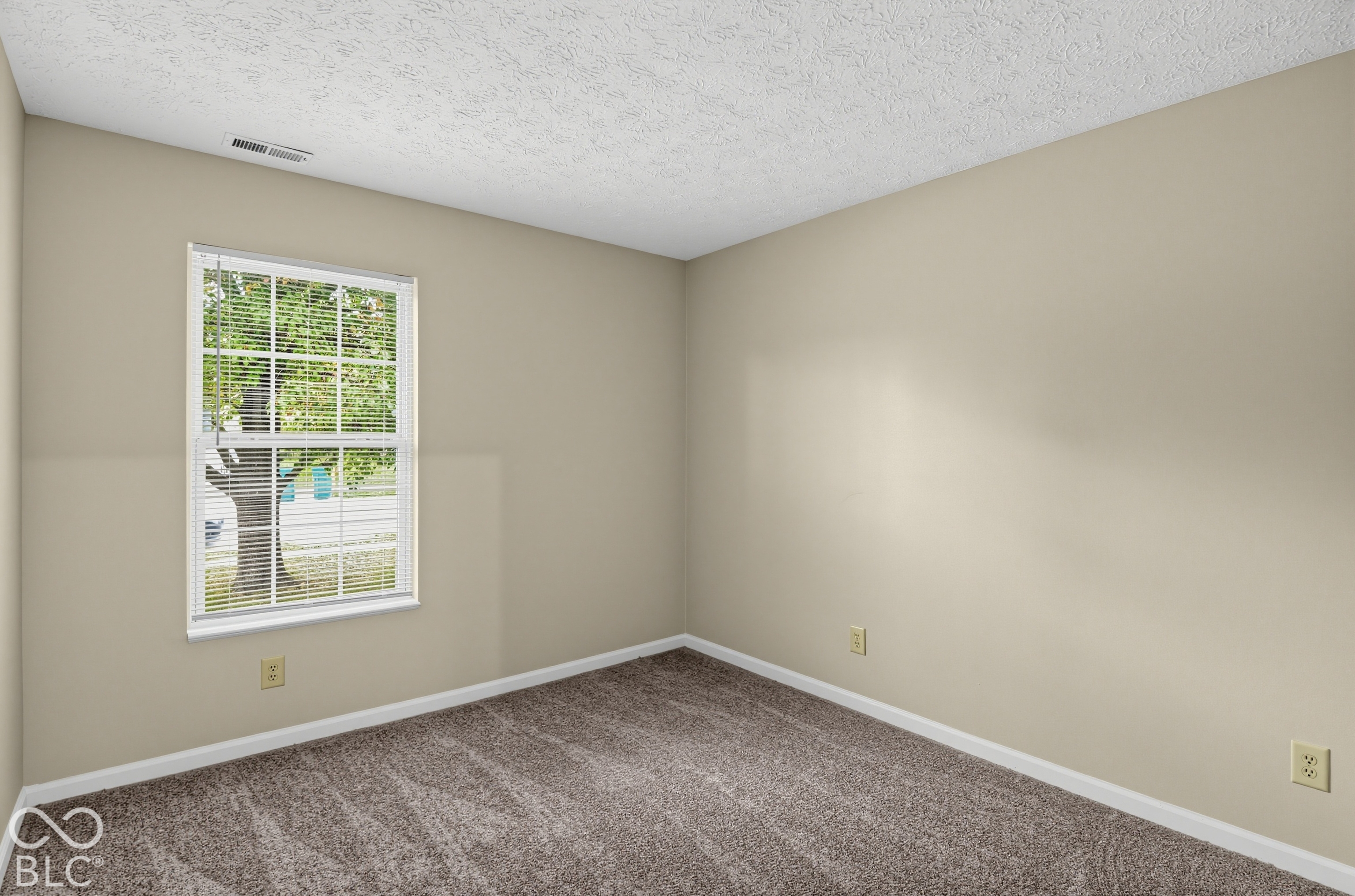 Room featuring neutral wall paint, carpeted flooring, and a window with horizontal blinds