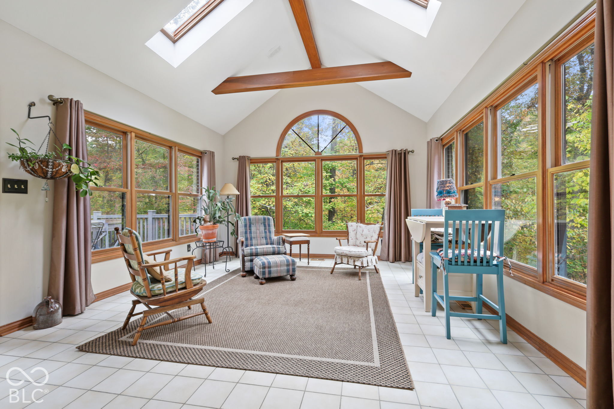Virtually Altered - Beautiful sunroom with vaulted ceiling overlooks the wooded property and pond