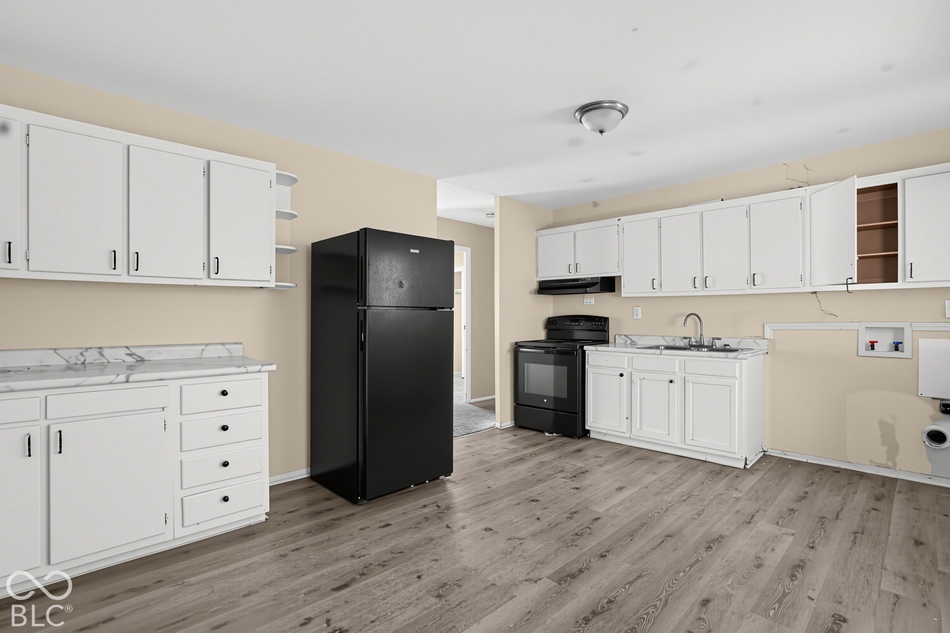 Kitchen featuring white cabinetry, stone-finish countertops, wood-finish flooring, and black appliances