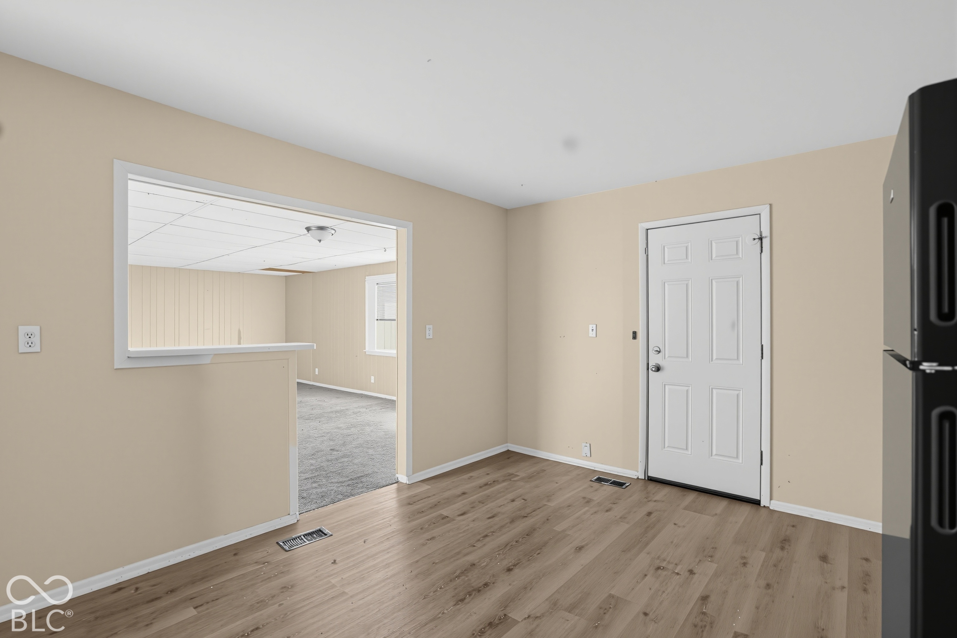Wood-finish flooring, interior six-panel door, and open wall pass-through