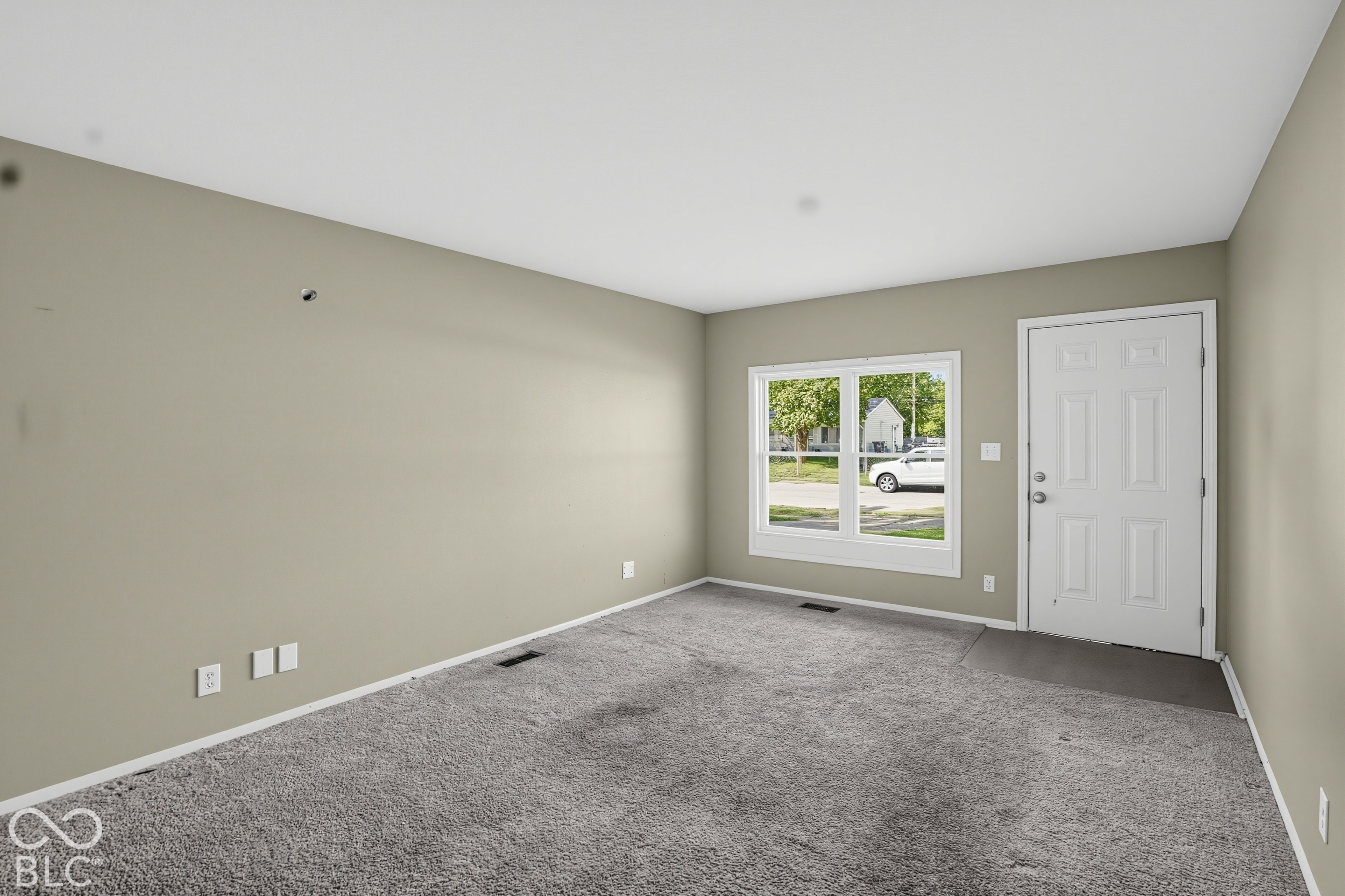 Interior space featuring wall-to-wall carpeting, neutral-toned walls, and a multi-pane window