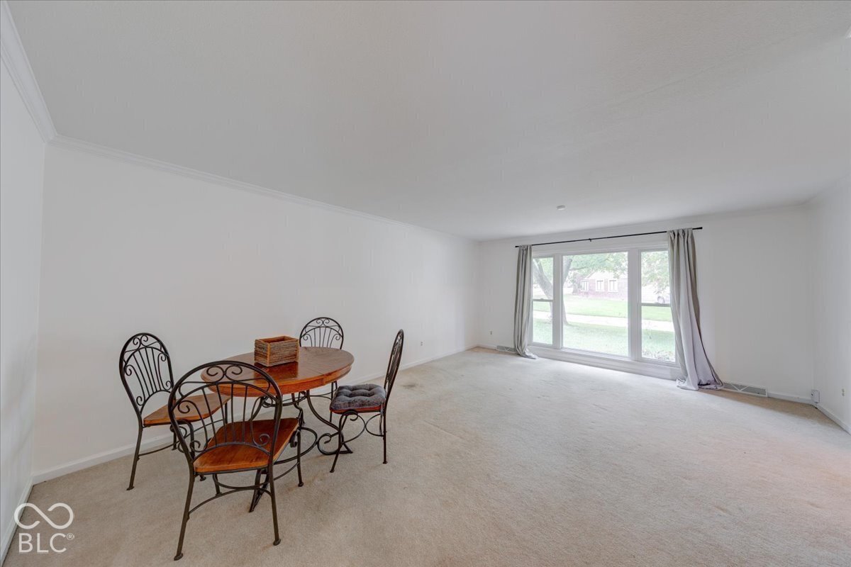 Neutral-toned wall-to-wall carpeting and large picture windows with a multi-pane configuration