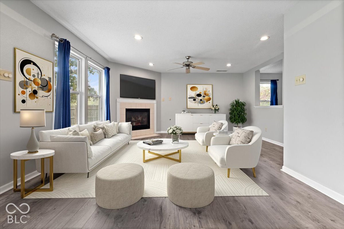 Virtually Altered - Living area featuring wood-finish flooring, recessed lighting, ceiling fan, and a fireplace with tile surround
