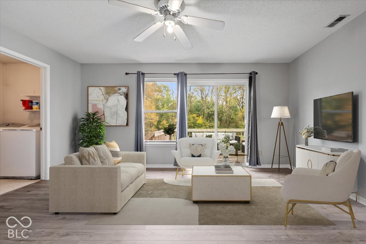 Virtually Altered - Living area featuring wood-finish flooring, sliding glass door, ceiling fan, and access to a deck