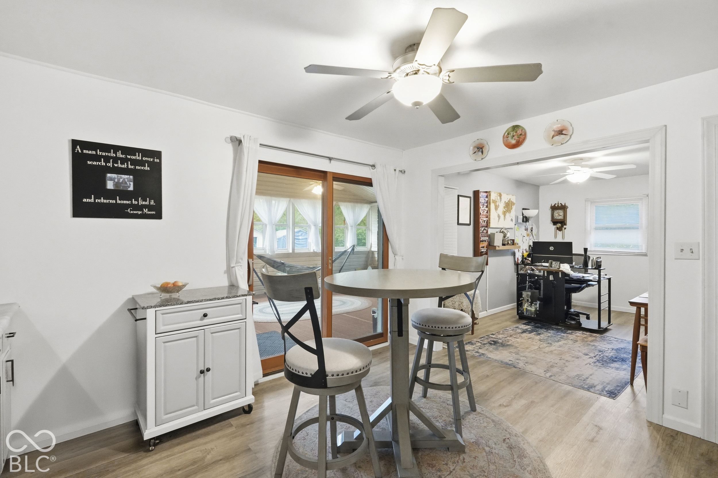 Another view of the kitchen that faces the office. Vinyl plank flooring, ceiling fan with integrated lighting, and sliding glass doors.