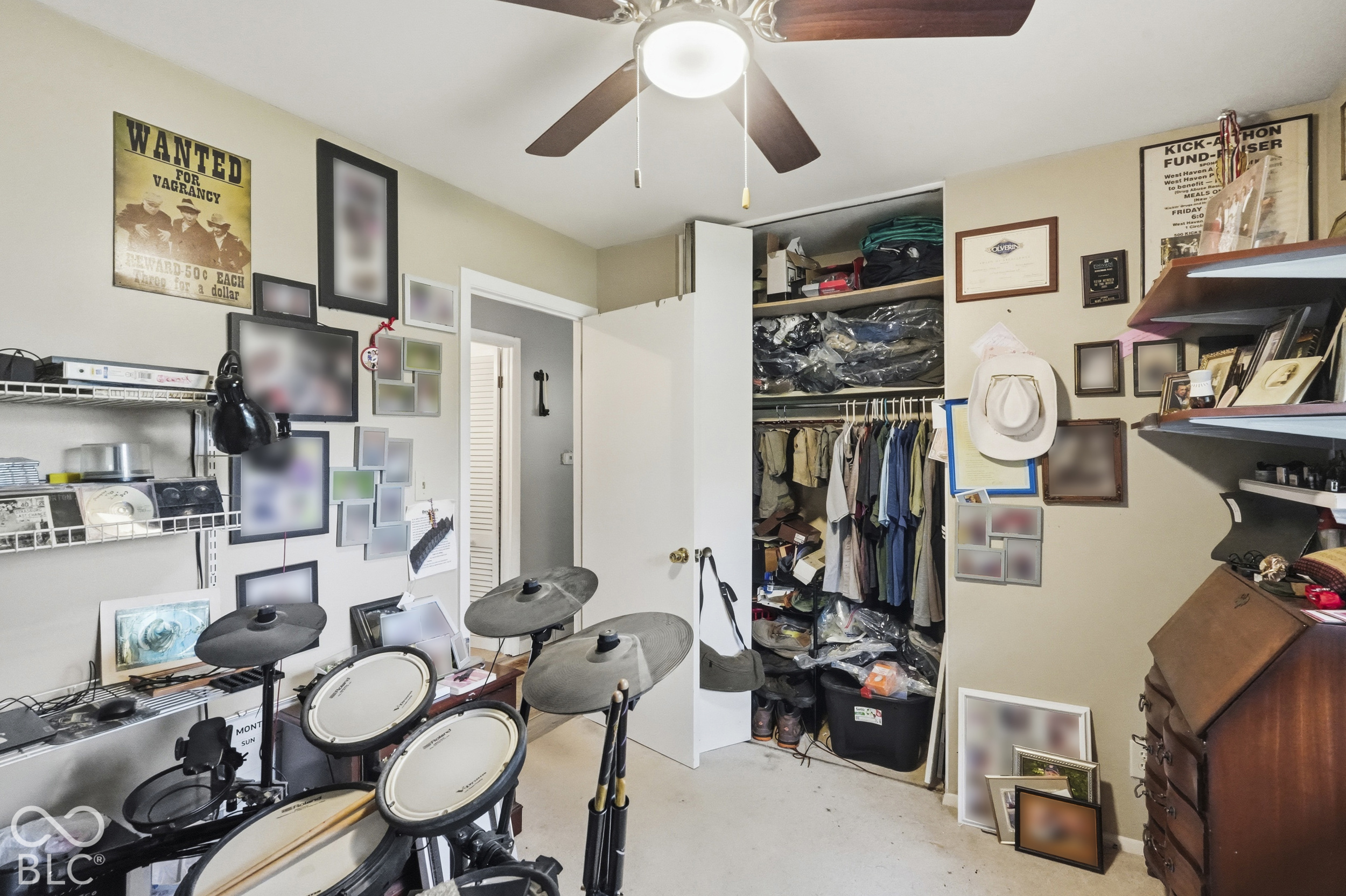 In this bedroom features a ceiling fan with integrated lighting, wall-mounted wire shelving, and a built-in closet with sliding doors.