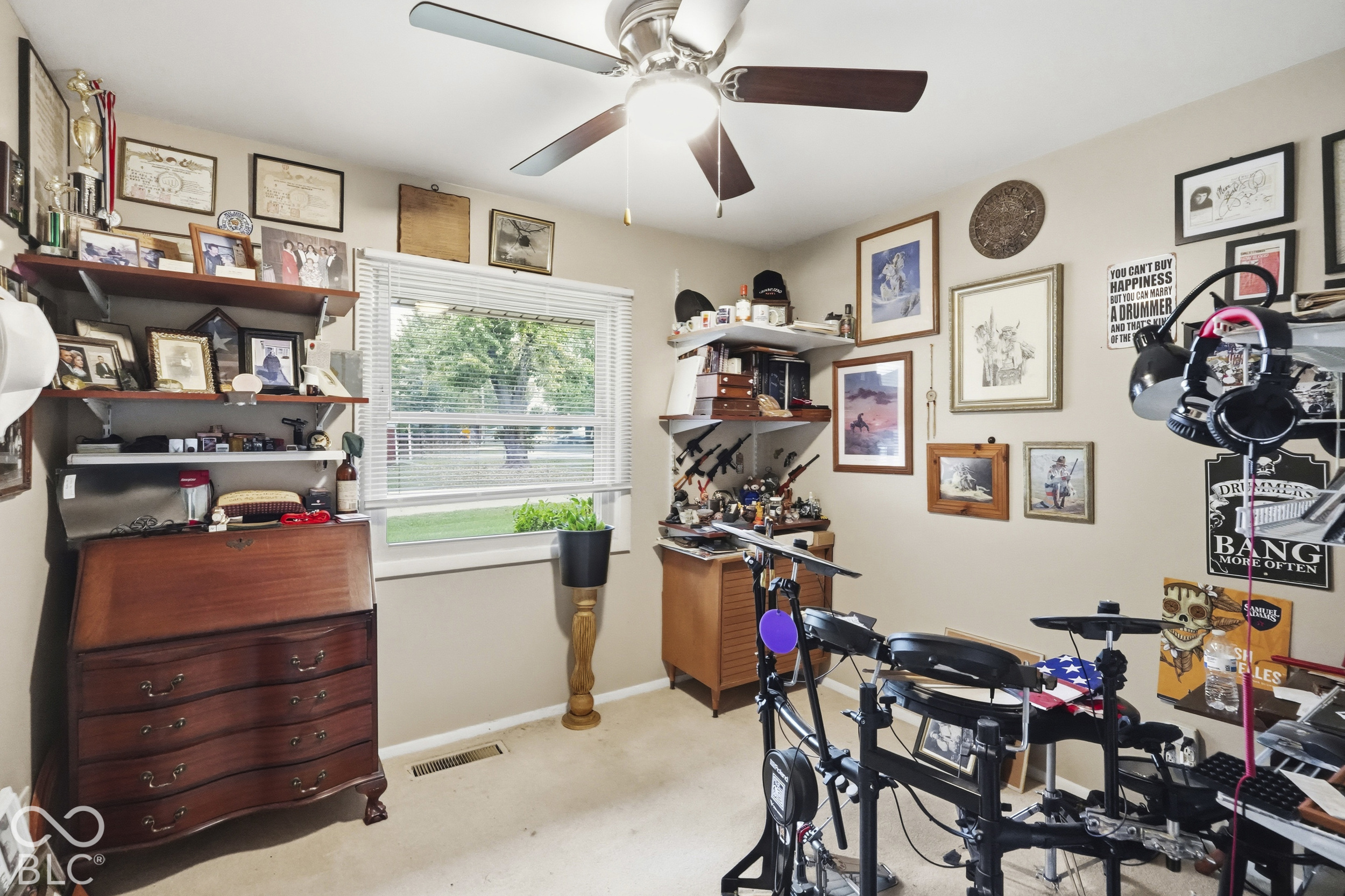 Interior space featuring a ceiling fan with integrated lighting, wall-mounted shelving units, and a single-hung window with horizontal blinds
