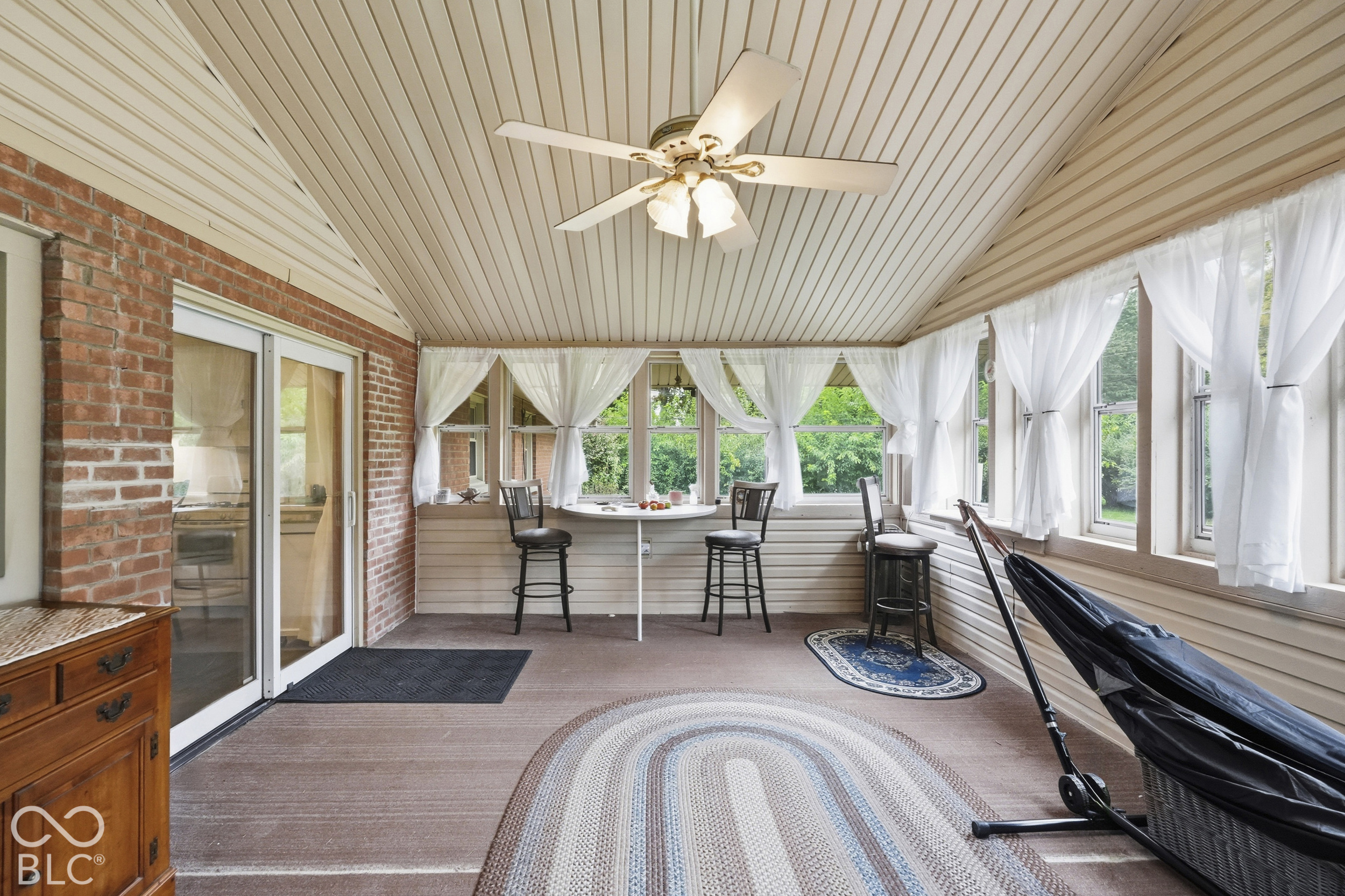 This view of the sun room shows the sliding glass door that leads into the kitchen. Notice all of the windows inviting the sunshine.