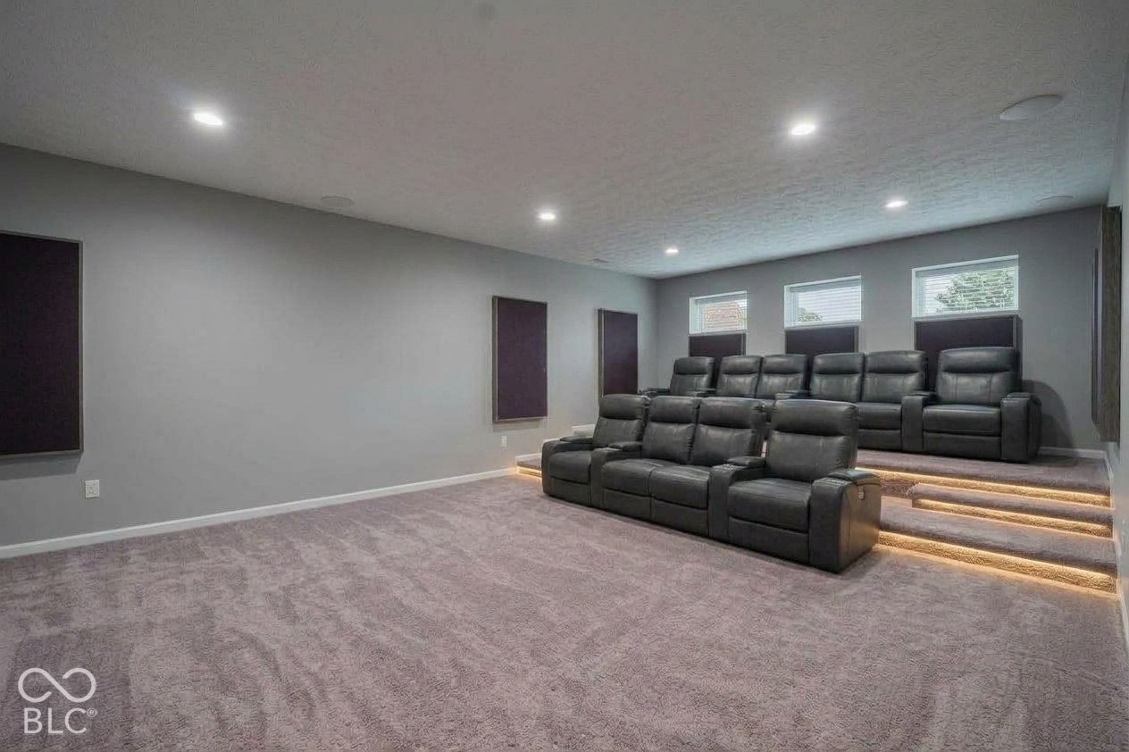 Virtually Altered - Dedicated space featuring tiered flooring, recessed stair lighting, integrated ceiling speakers, and wall-mounted acoustic panels