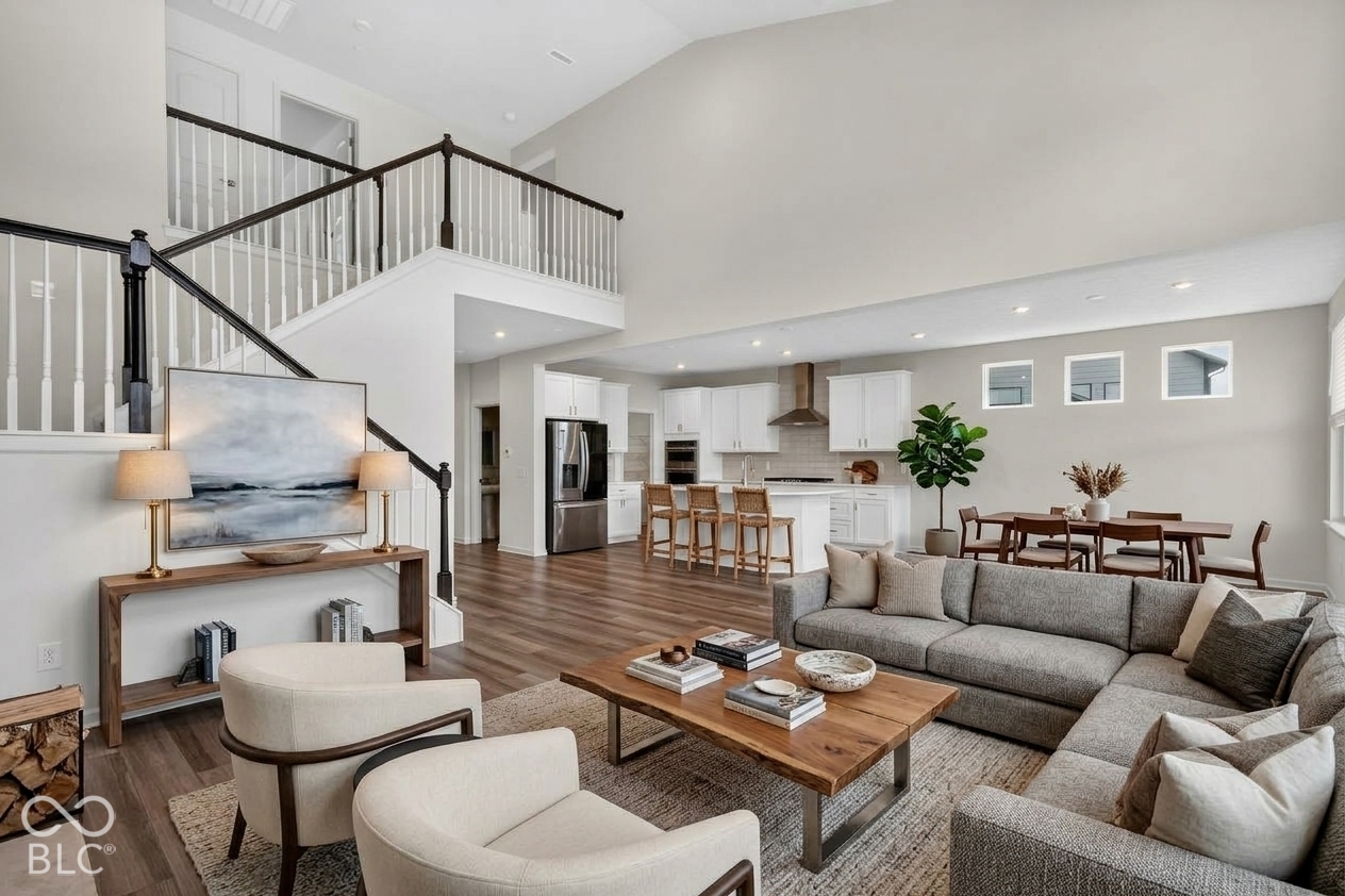 Virtually Altered - Vaulted ceilings with recessed lighting, wood-finish flooring, staircase with wood and metal railing, kitchen island with built-in cabinetry, and integrated stainless steel appliances