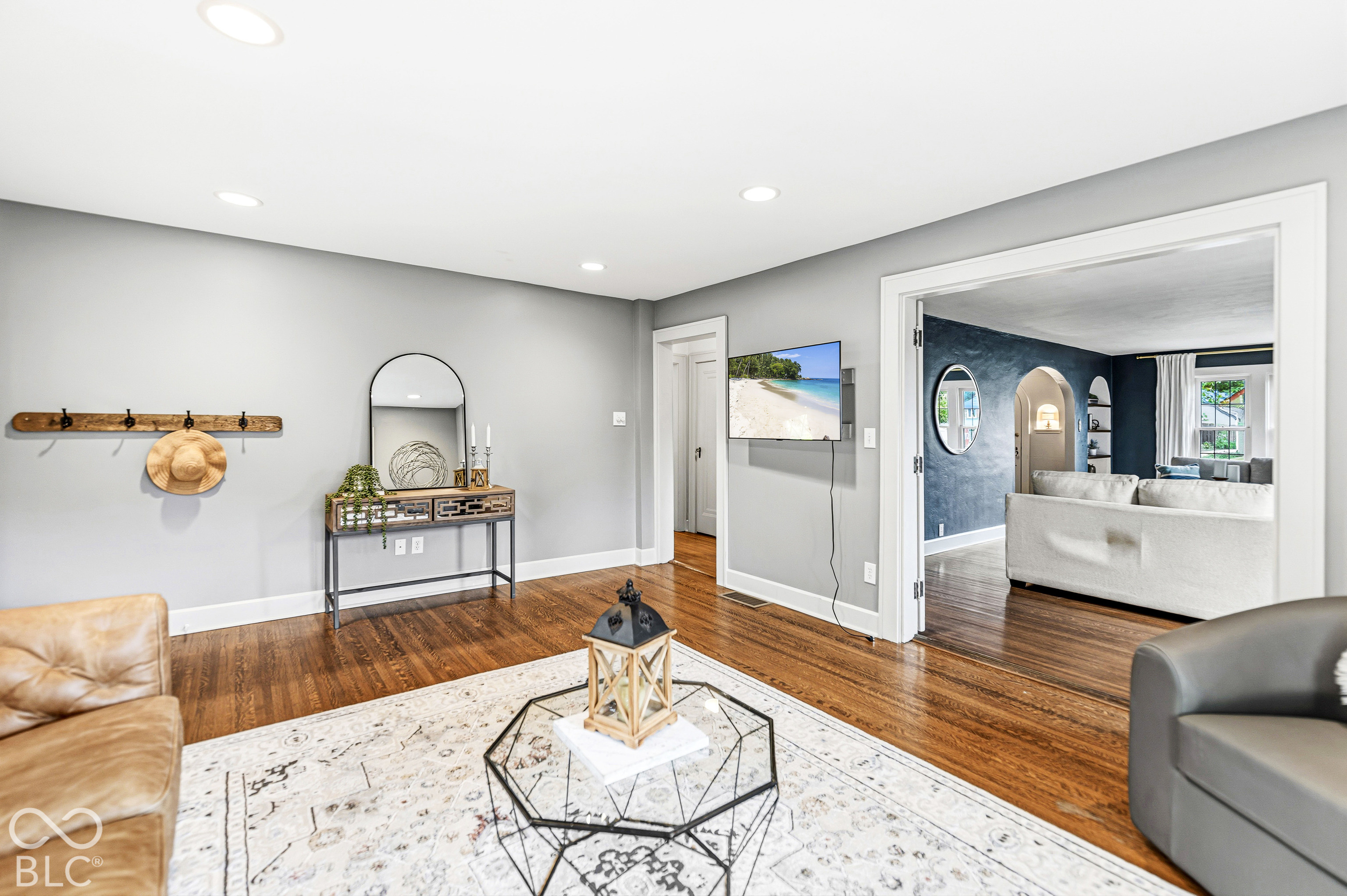 Interior space featuring wood-finish flooring, recessed lighting, and a wide cased opening with thick white trim
