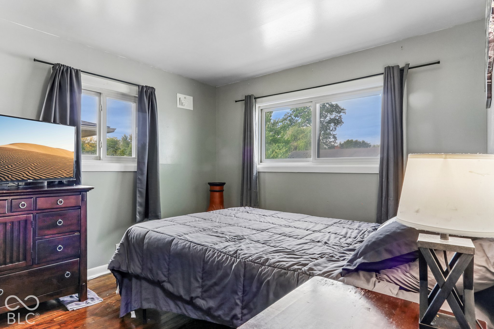 Bedroom featuring wood-finish flooring and dual slider windows